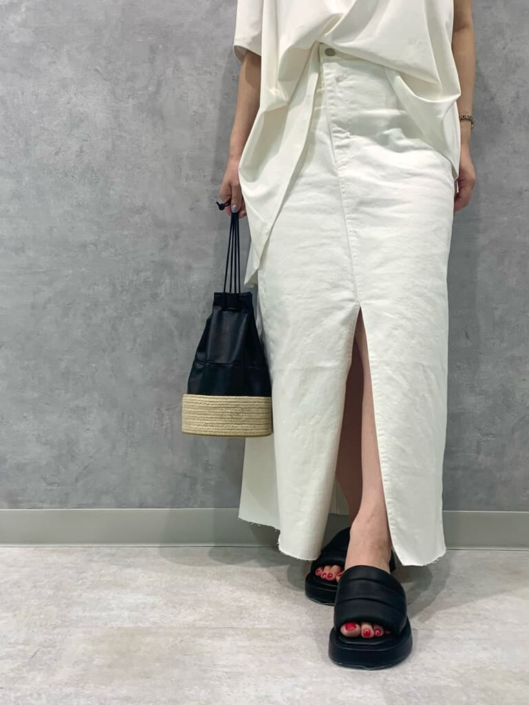 ブラック系のハンドバッグ、ホワイト系のデニムスカート、ブラック系のサンダルを着用したレディースの夏コーディネートの5枚目の写真