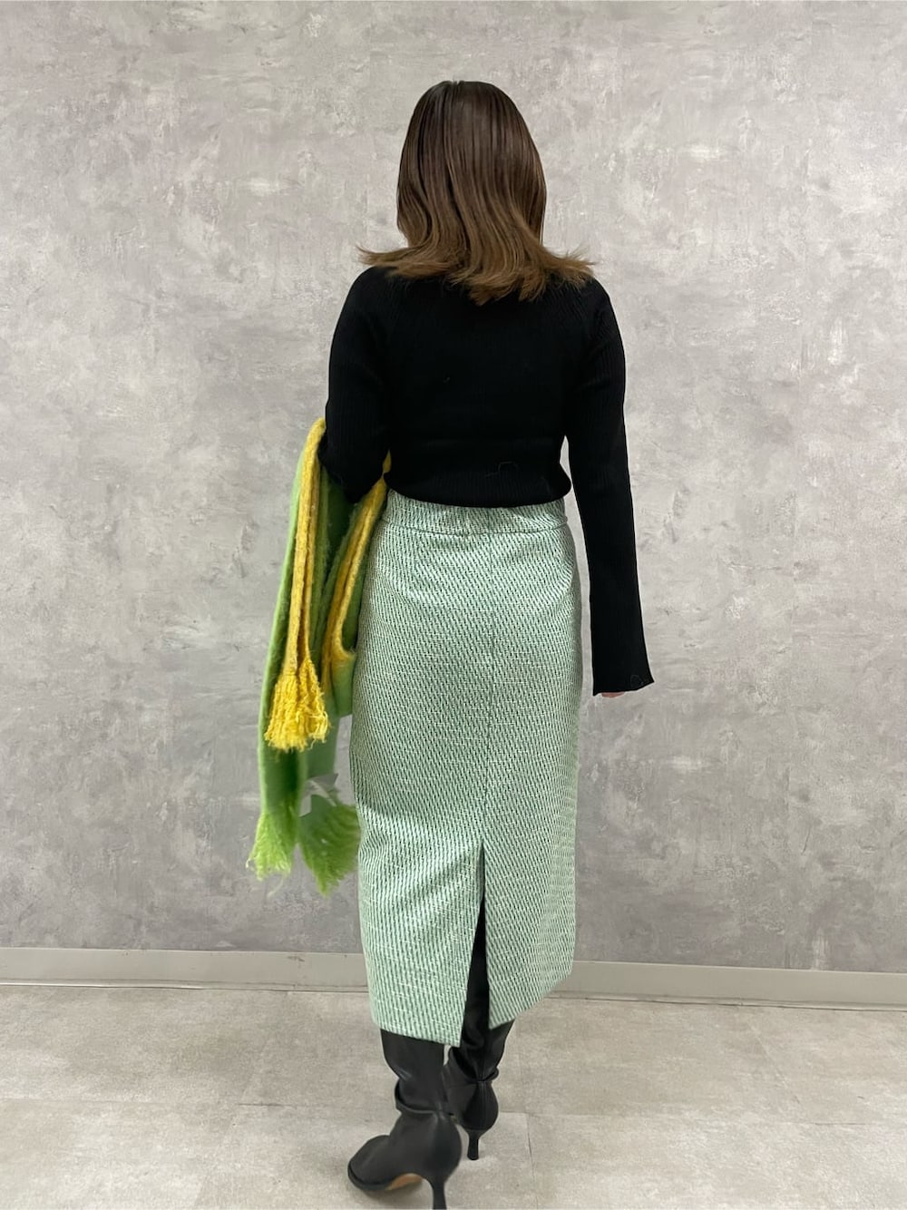 ブラック系のニット/セーター、その他のスカート、グリーン系のストール/ショールを着用したレディースの秋コーディネートの2枚目の写真