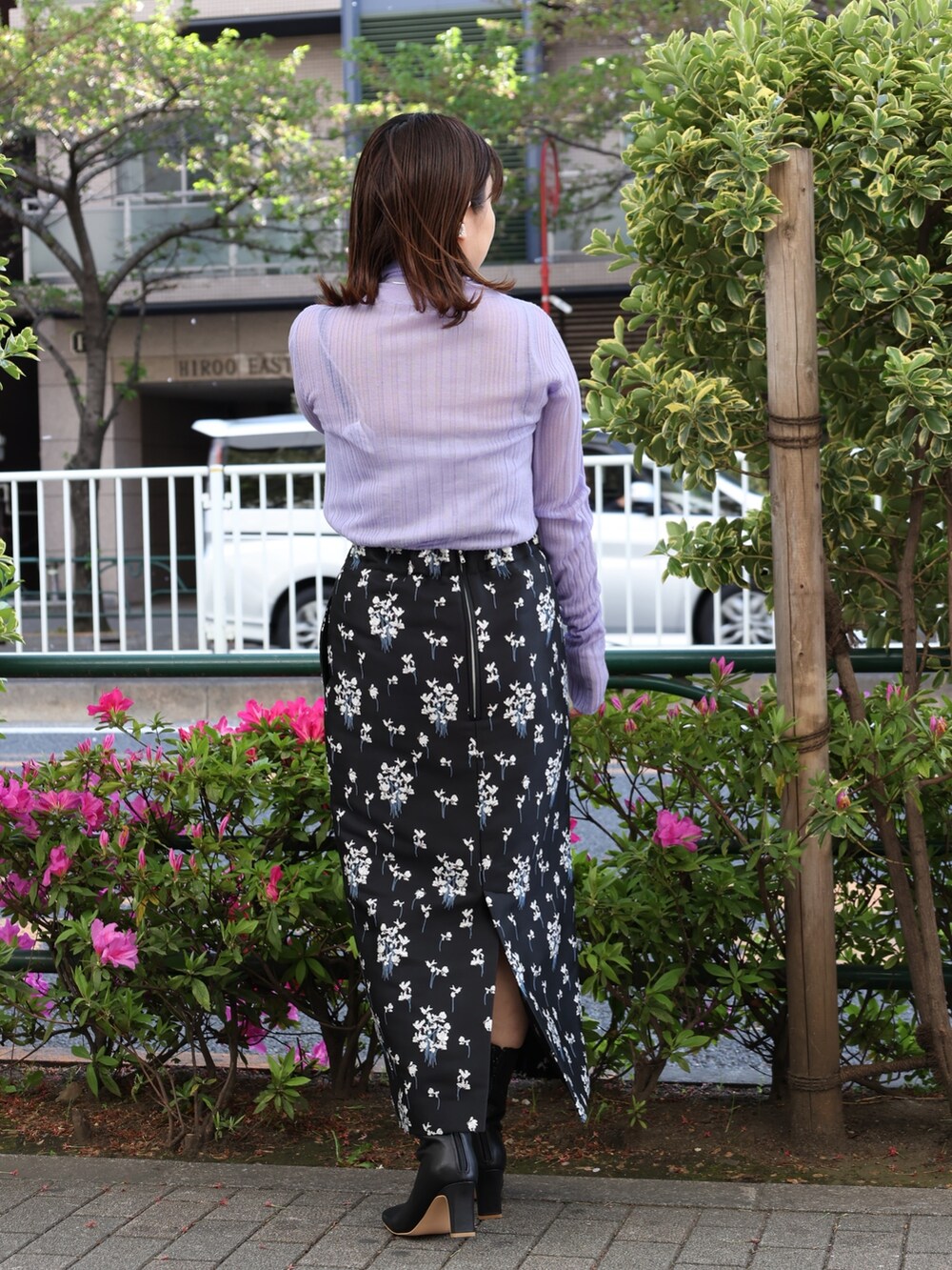 ブラック系のブーツ、パープル系のニット/セーター、ブラック系のスカートを着用したレディースの春コーディネートの2枚目の写真