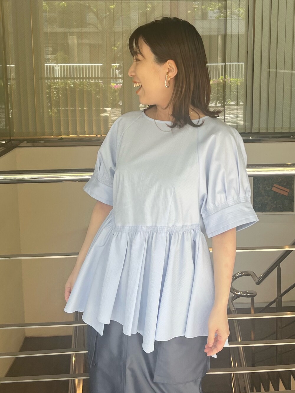 ブルー系のシャツ/ブラウス、ブルー系のスカート、ブラック系のブーツを着用したレディースの春コーディネートの4枚目の写真