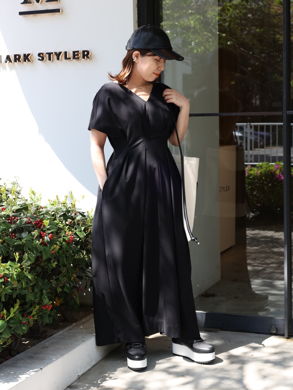 ブラック系のスニーカー、その他のトートバッグ、ブラック系のワンピースを着用したレディースの春コーディネートの2枚目の写真