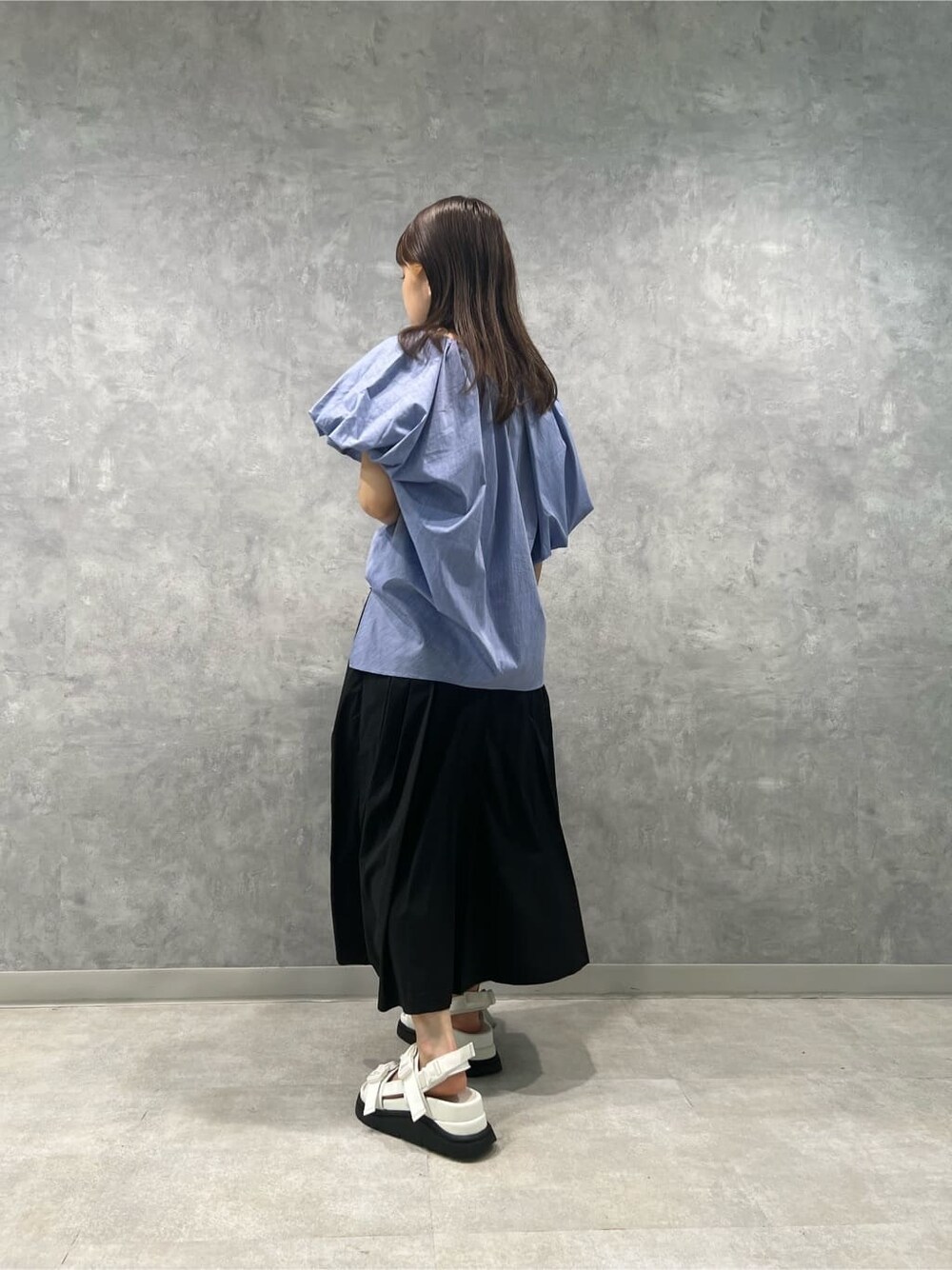 ホワイト系のサンダル、ブルー系のシャツ/ブラウス、ブラック系のスカートを着用したレディースの夏コーディネートの2枚目の写真