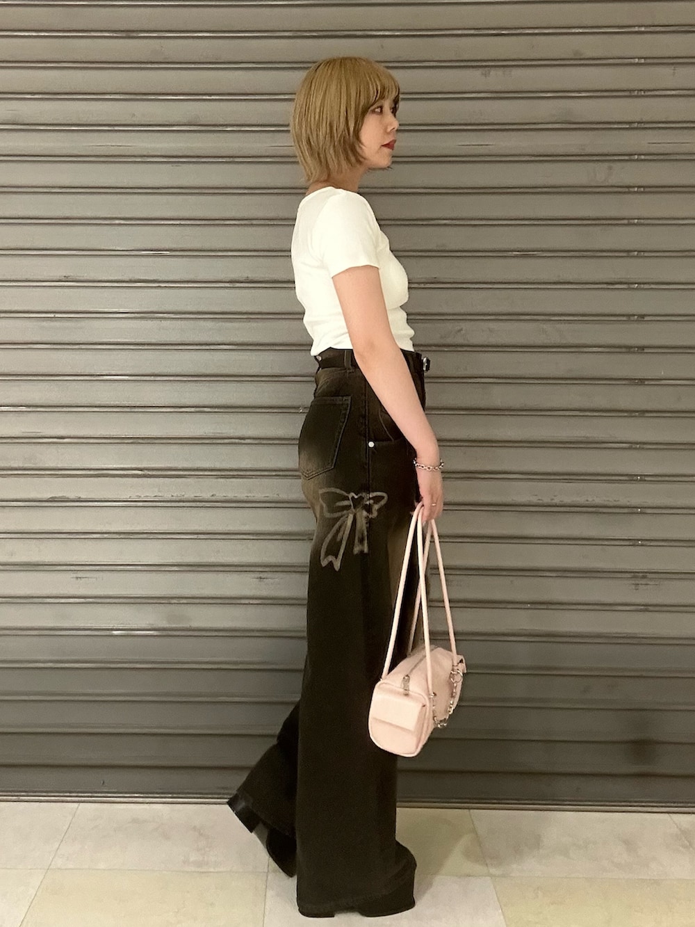 ホワイト系のTシャツ/カットソー、ブラック系のデニムパンツ、ブラック系のサンダルを着用したレディースの夏コーディネートの2枚目の写真