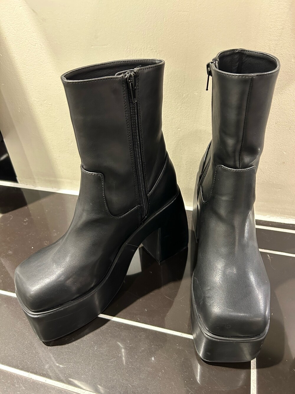 ブラック系のニット/セーター、ブラック系のブーツ、ブラック系のデニムパンツを着用したレディースの秋コーディネートの6枚目の写真