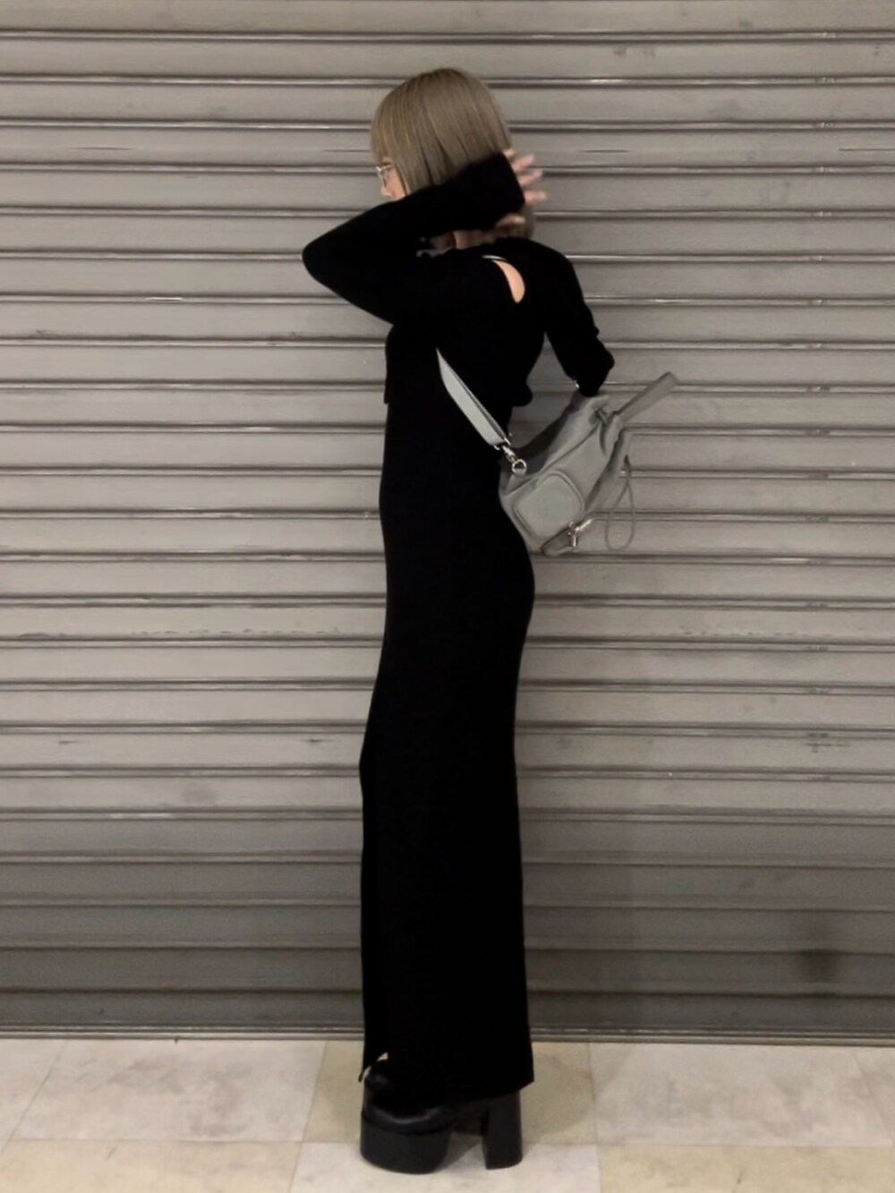 ブラック系のワンピース、ブラック系のハンドバッグ、ブラック系のブーツを着用したレディースの秋コーディネートの4枚目の写真