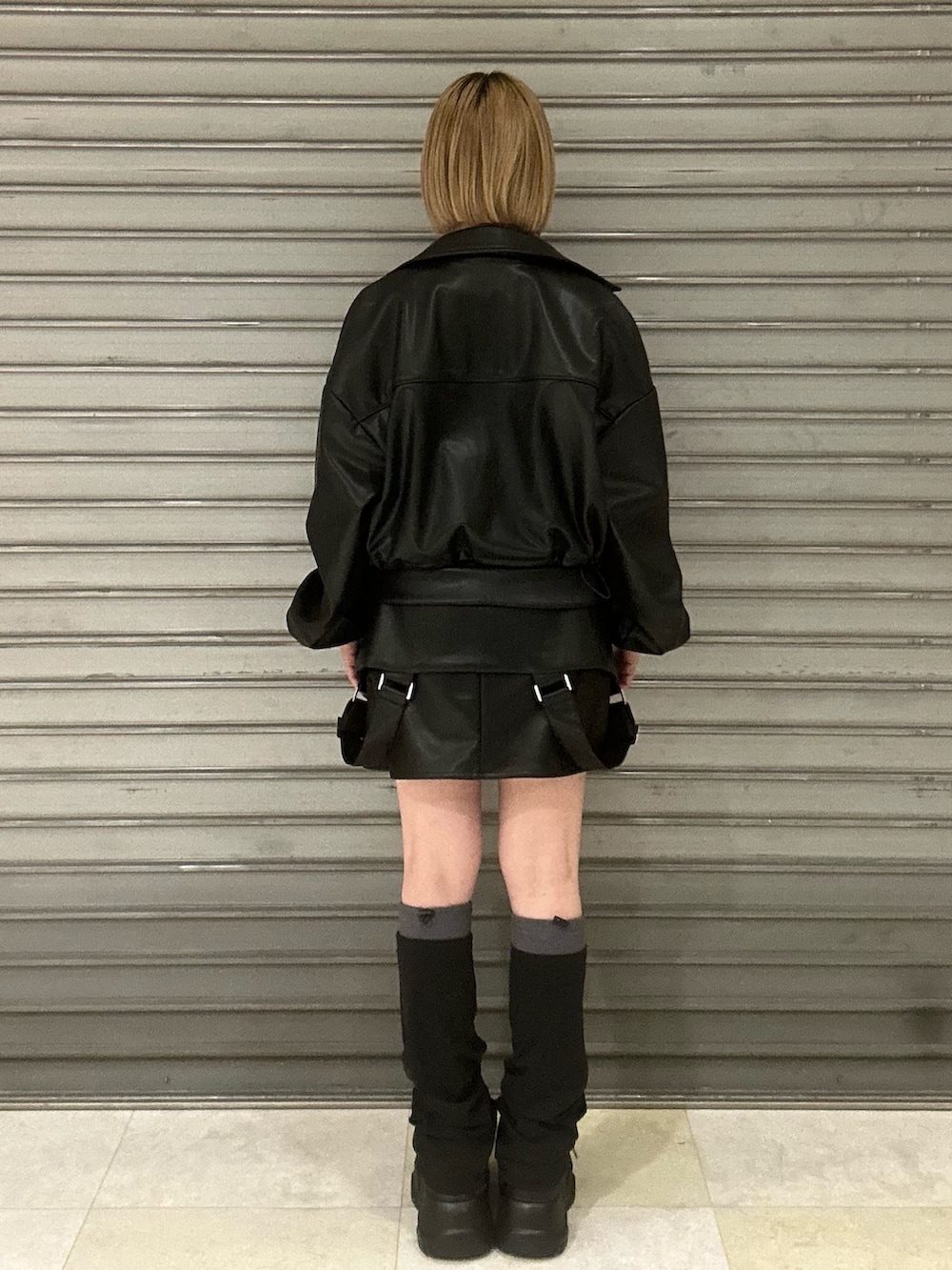 ブラック系のブルゾン、ホワイト系のニット/セーター、ブラック系のスカートを着用したレディースの冬コーディネートの3枚目の写真