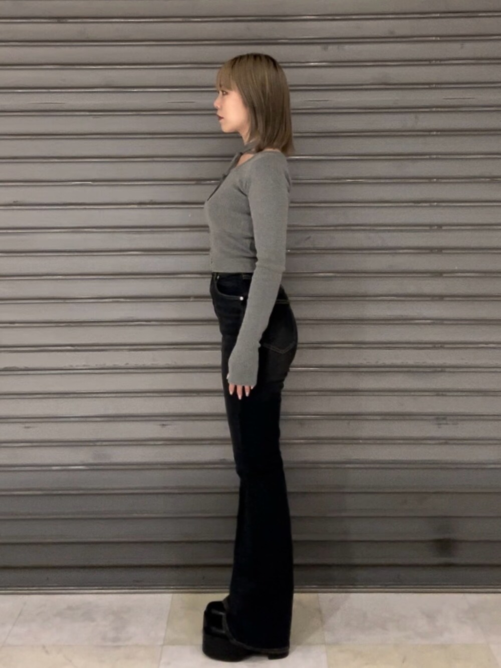 ブルー系のデニムパンツ、グレー系のニット/セーター、ブラック系のブーツを着用したレディースの秋コーディネートの4枚目の写真