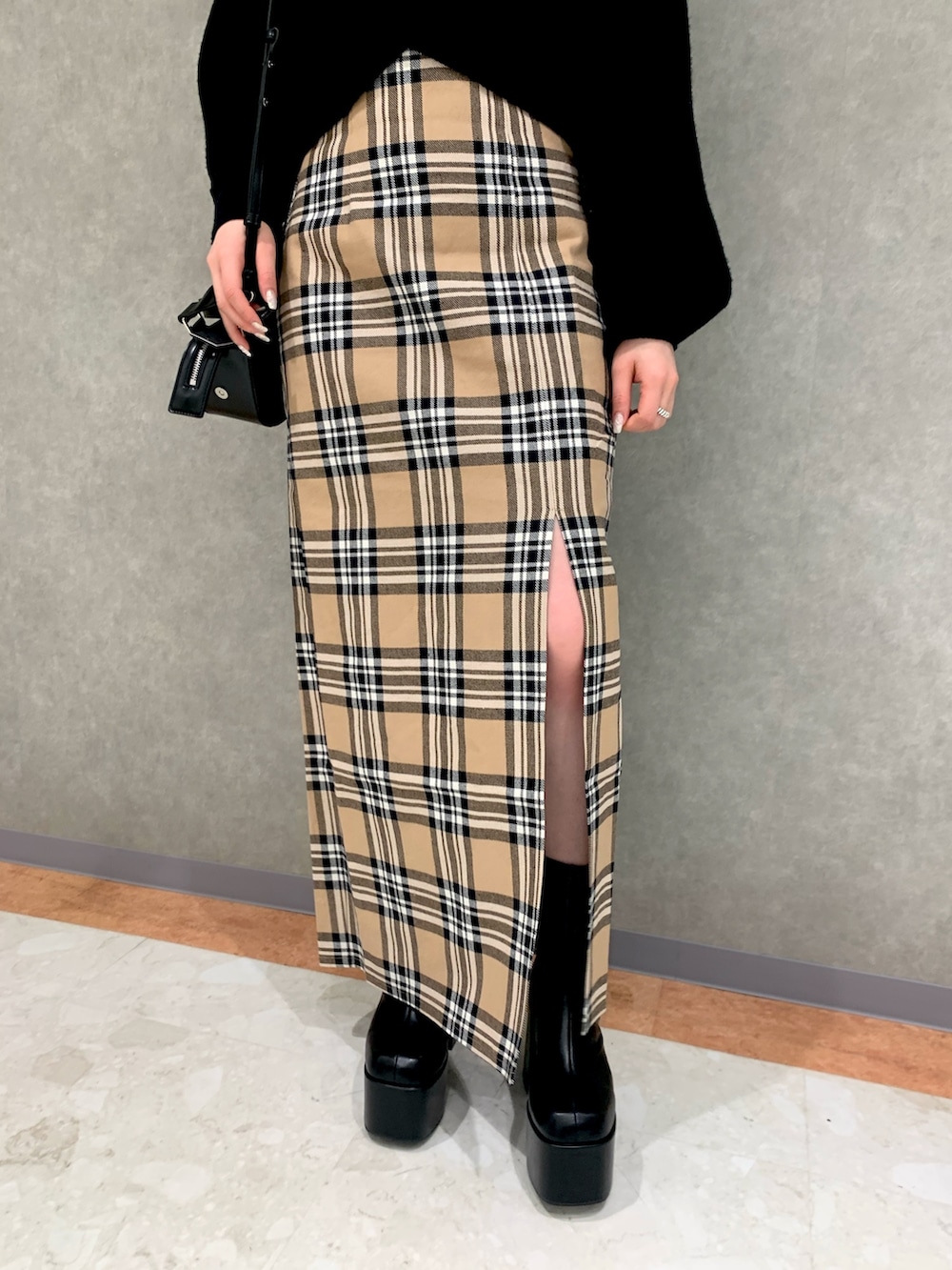 その他のスカート、ブラック系のニット/セーター、ブラック系のハンドバッグを着用したレディースの冬コーディネートの3枚目の写真