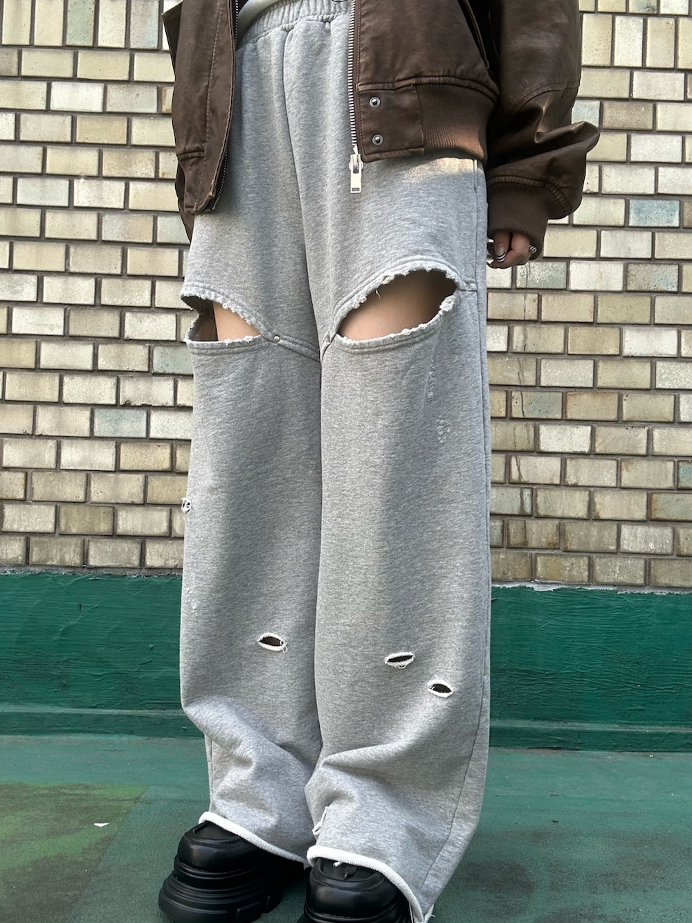 ブラウン系のブルゾン、ホワイト系のTシャツ/カットソー、グレー系のスウェットパンツを着用したレディースの秋コーディネートの6枚目の写真