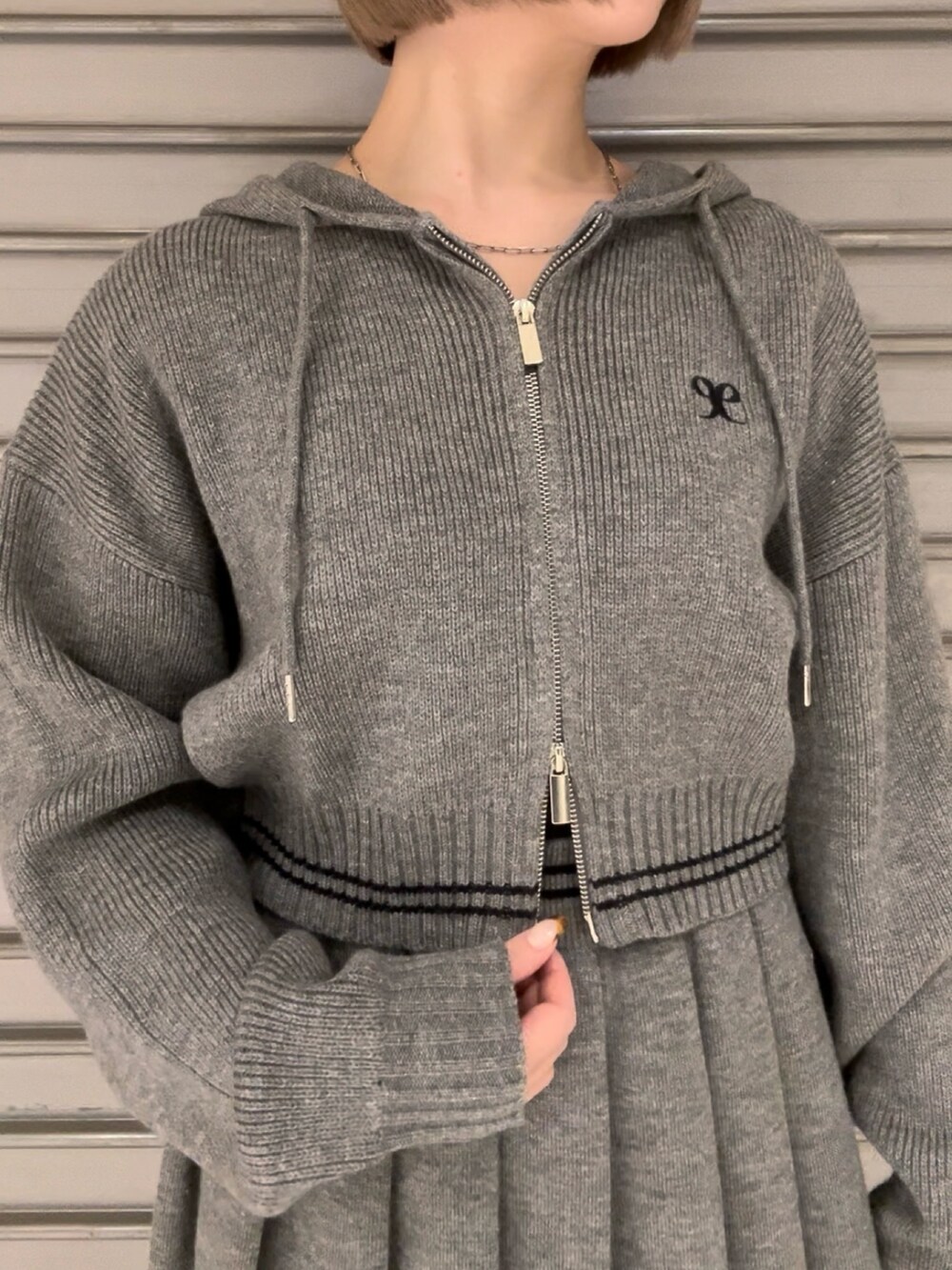 グレー系のニット/セーター、グレー系のスカート、その他のブーツを着用したレディースの秋コーディネートの5枚目の写真