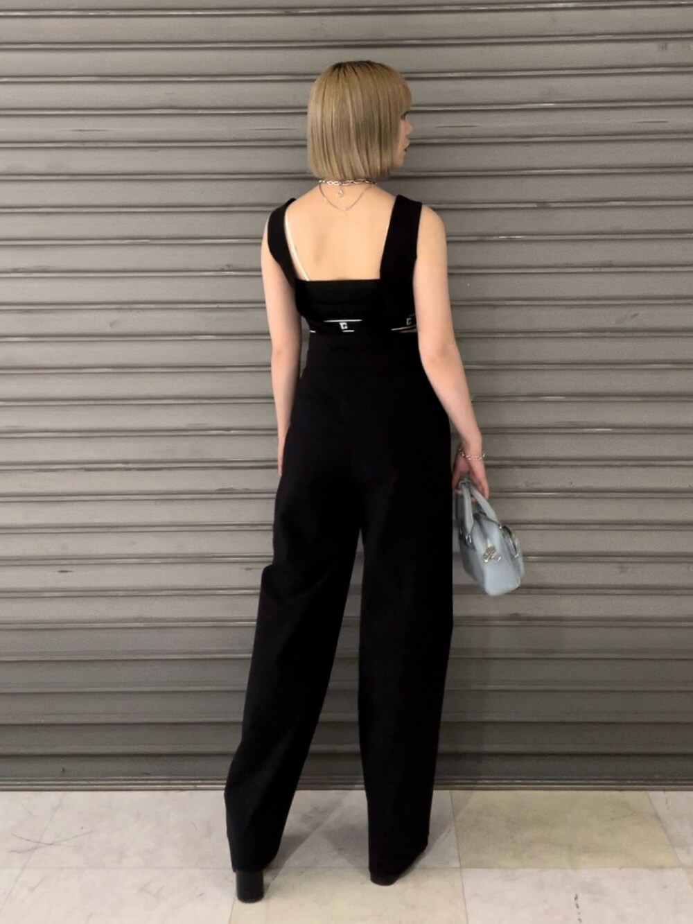 ブラック系のつなぎ/オールインワン、ブラック系のサンダル、ブルー系のハンドバッグを着用したレディースの春コーディネートの3枚目の写真