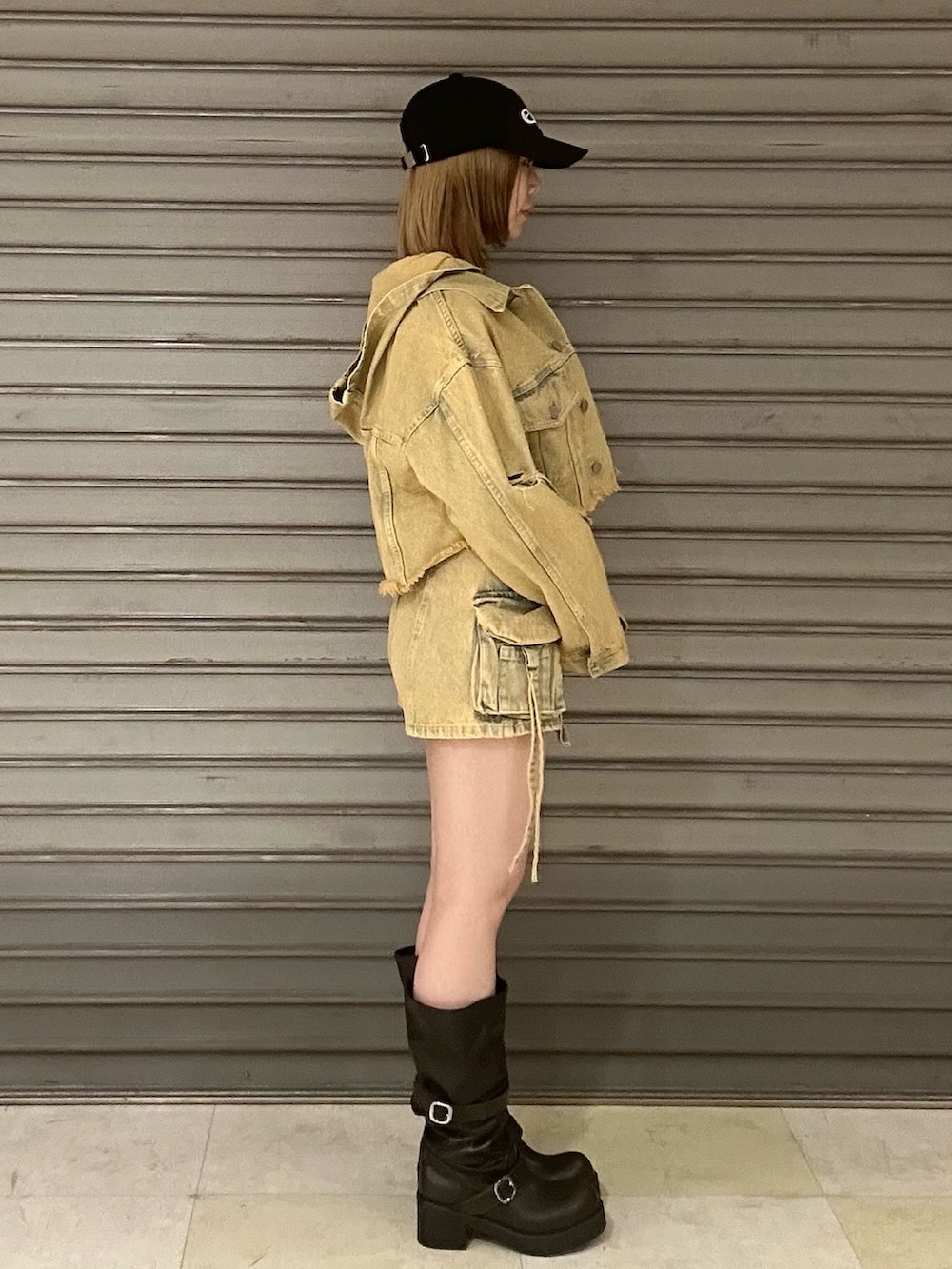 ブラック系のブーツ、ホワイト系のTシャツ/カットソー、ベージュ系のデニムジャケットを着用したレディースの春コーディネートの3枚目の写真