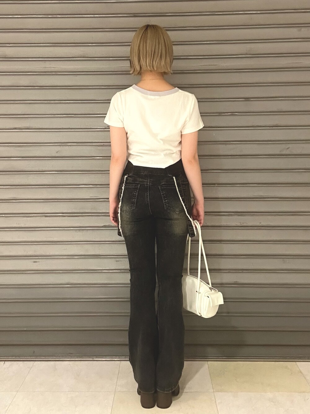 ホワイト系のTシャツ/カットソー、ブルー系のデニムパンツ、ホワイト系のハンドバッグを着用したレディースの夏コーディネートの3枚目の写真