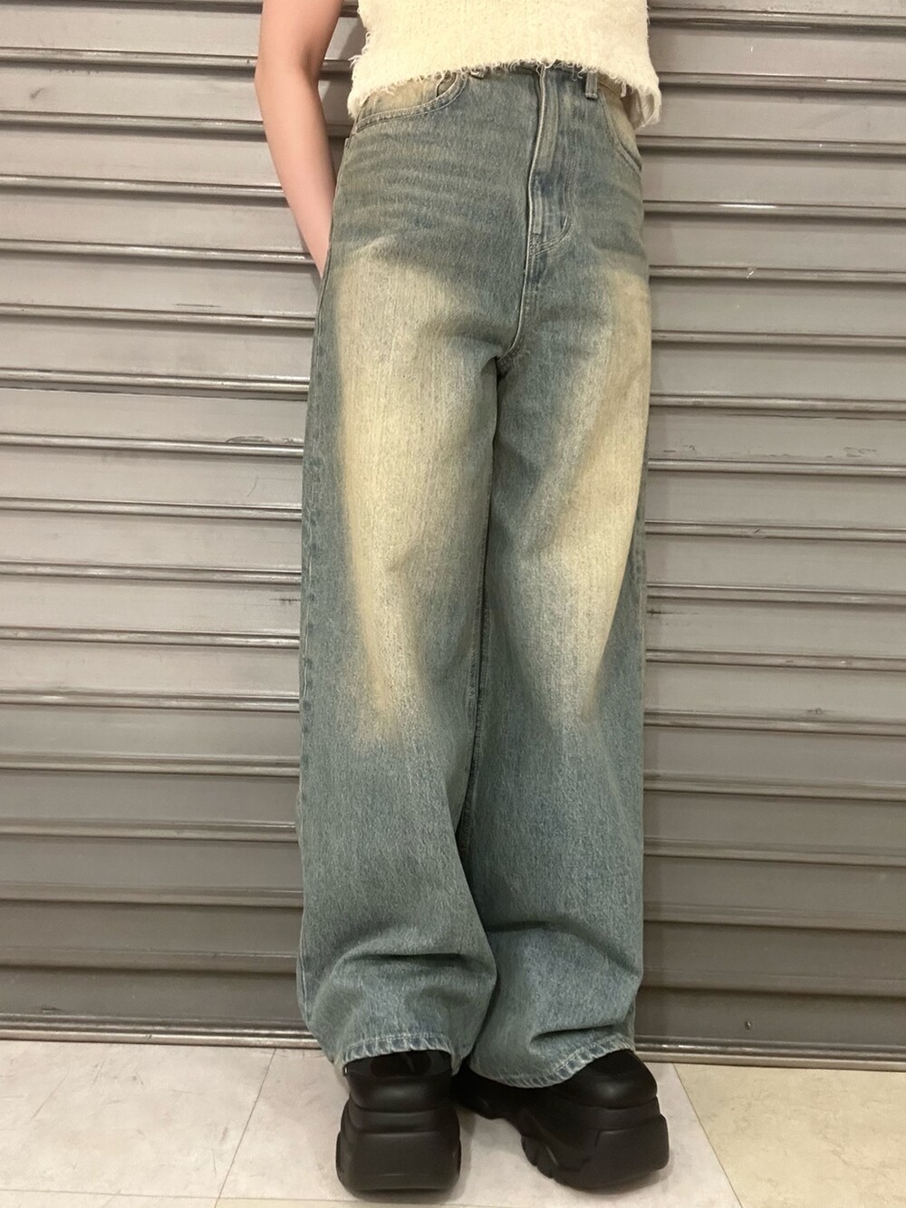 ホワイト系のニット/セーター、ホワイト系のTシャツ/カットソー、ブルー系のデニムパンツを着用したレディースの春コーディネートの6枚目の写真