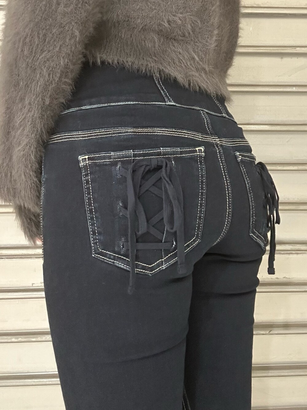 グレー系のニット/セーター、グレー系のTシャツ/カットソー、ブルー系のデニムパンツを着用したレディースの秋コーディネートの6枚目の写真