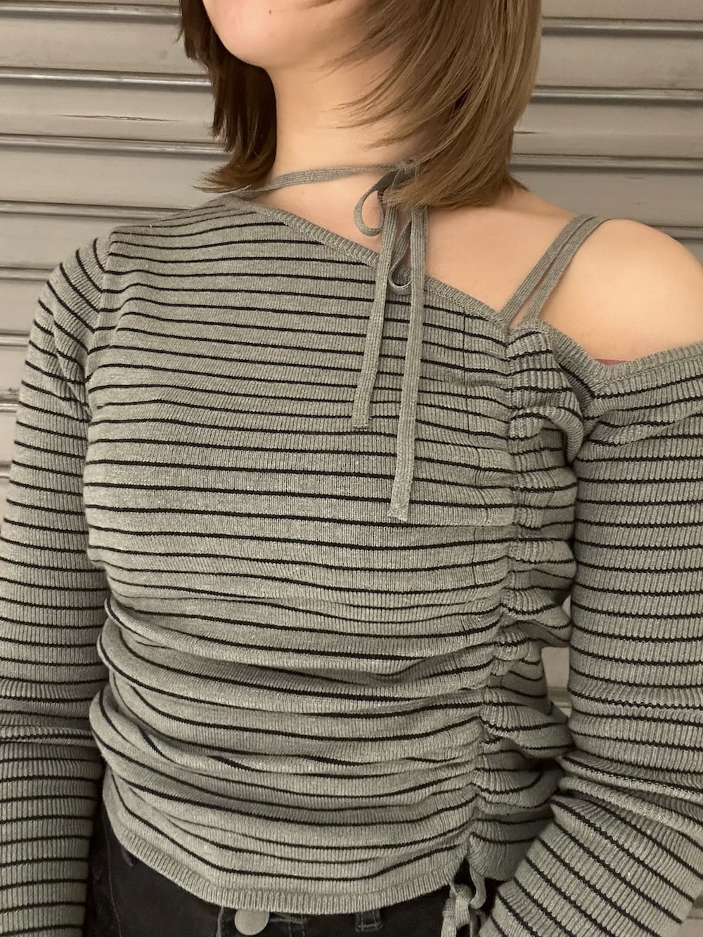 ブラック系のブーツ、グレー系のニット/セーター、ブラック系のデニムパンツを着用したレディースの冬コーディネートの4枚目の写真