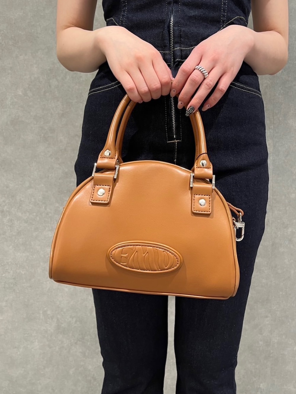 ブラウン系のハンドバッグ、ホワイト系のサンダル、ブルー系のつなぎ/オールインワンを着用したレディースの春コーディネートの5枚目の写真