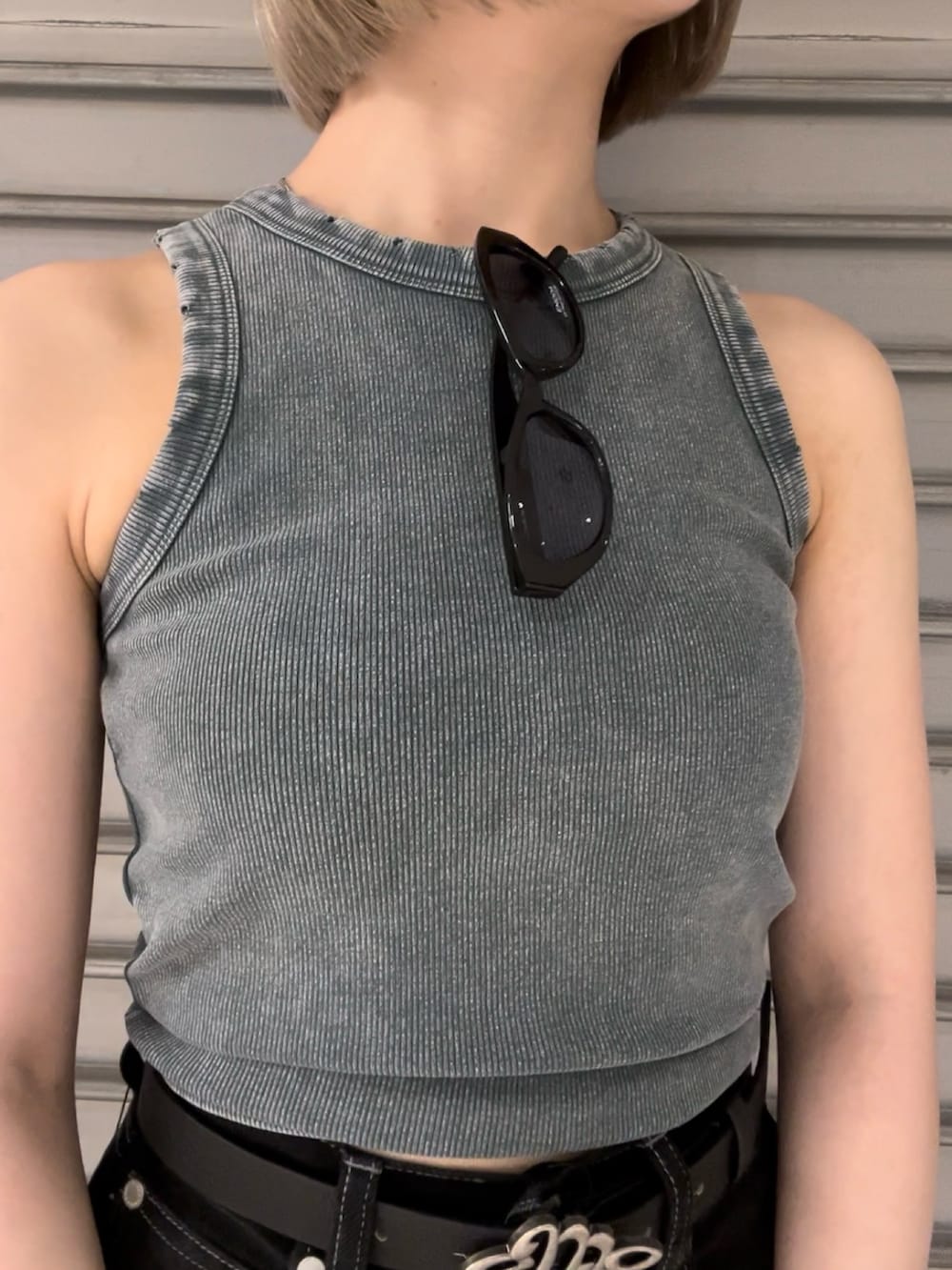 ブルー系のタンクトップ、ブラック系のデニムパンツ、ブラック系のハンドバッグを着用したレディースの夏コーディネートの4枚目の写真