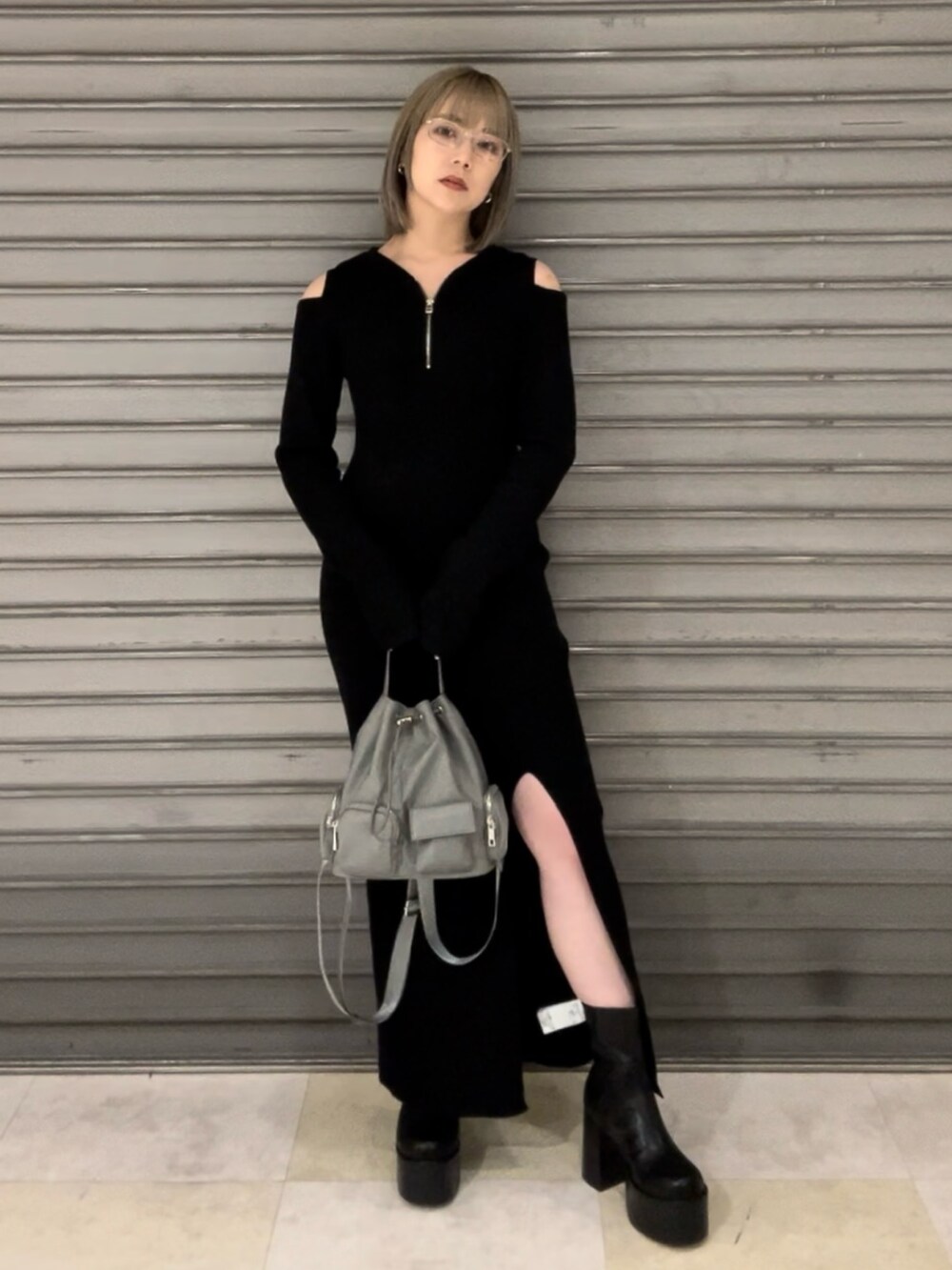 ブラック系のワンピース、ブラック系のハンドバッグ、ブラック系のブーツを着用したレディースの秋コーディネートの2枚目の写真