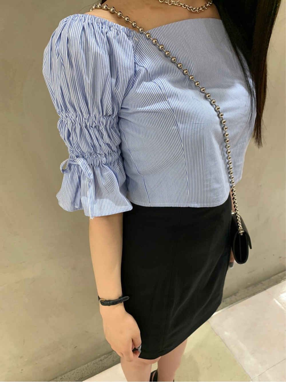 ブラック系のスカート、ブラック系のサンダル、ブルー系のシャツ/ブラウスを着用したレディースの夏コーディネートの3枚目の写真