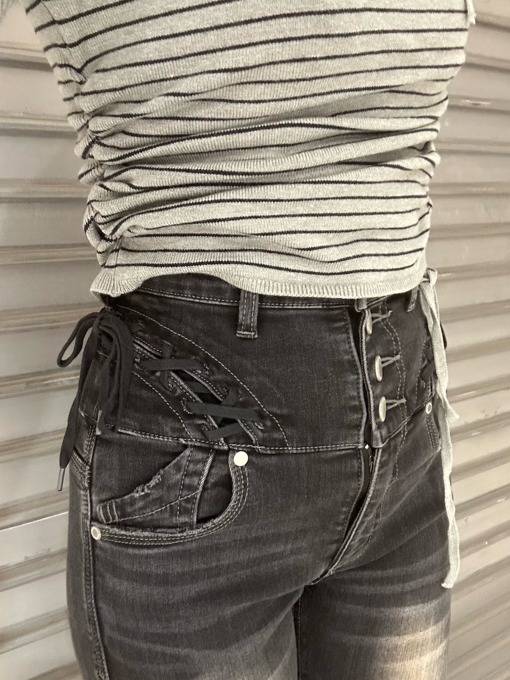 ブラック系のブーツ、グレー系のニット/セーター、ブラック系のデニムパンツを着用したレディースの冬コーディネートの5枚目の写真