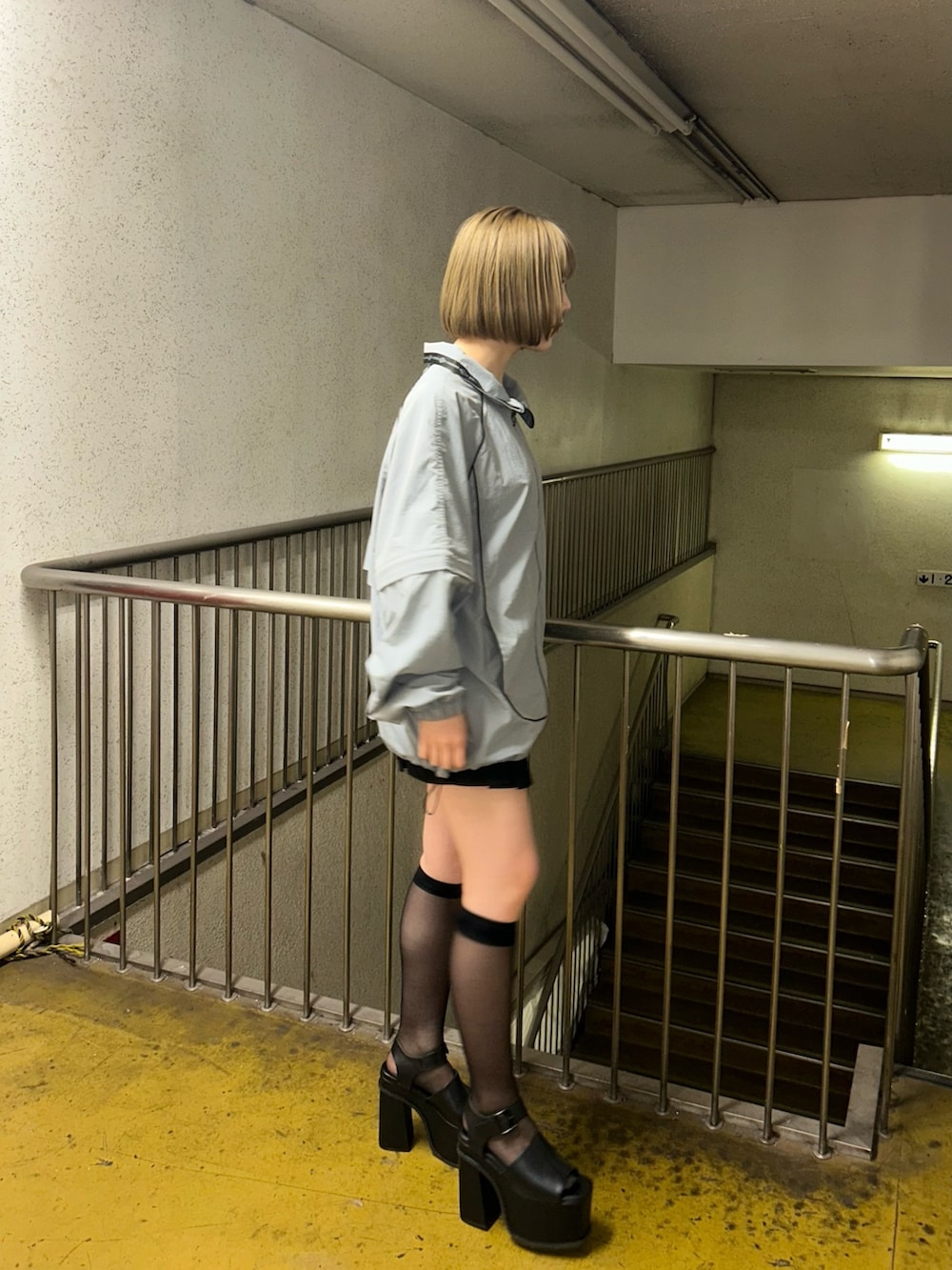 グレー系のブルゾン、ブラック系のスカート、ブラック系のサンダルを着用したレディースの春コーディネートの2枚目の写真