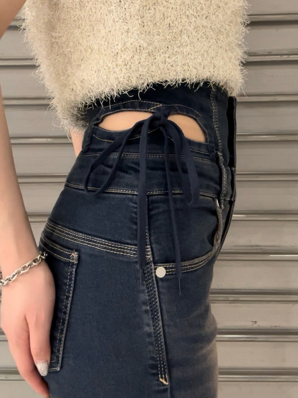 ホワイト系のタンクトップ、ブルー系のデニムパンツ、ブラック系のサンダルを着用したレディースの夏コーディネートの6枚目の写真