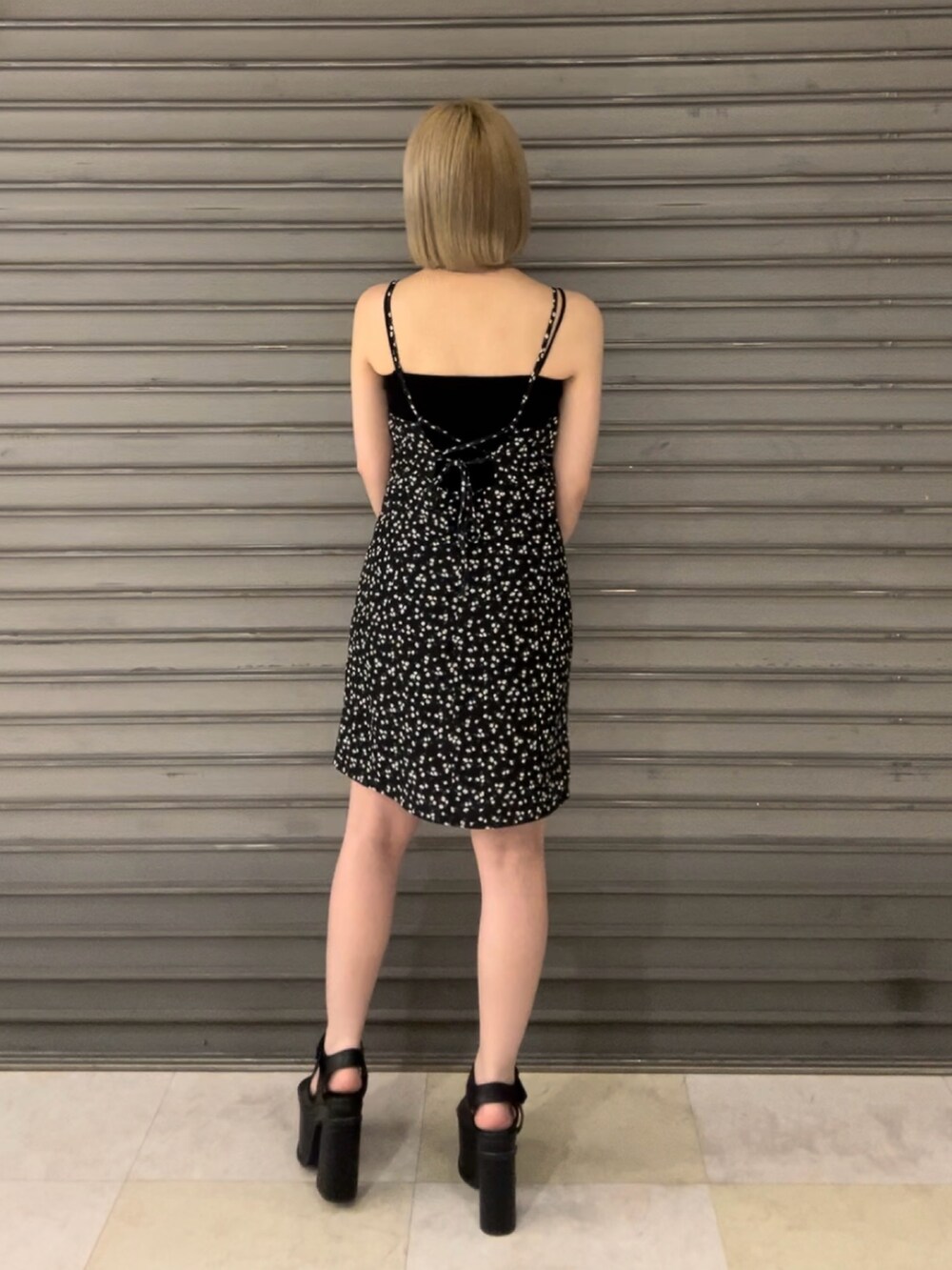 ブラック系のハンドバッグ、ブラック系のサンダル、その他のワンピースを着用したレディースの夏コーディネートの3枚目の写真