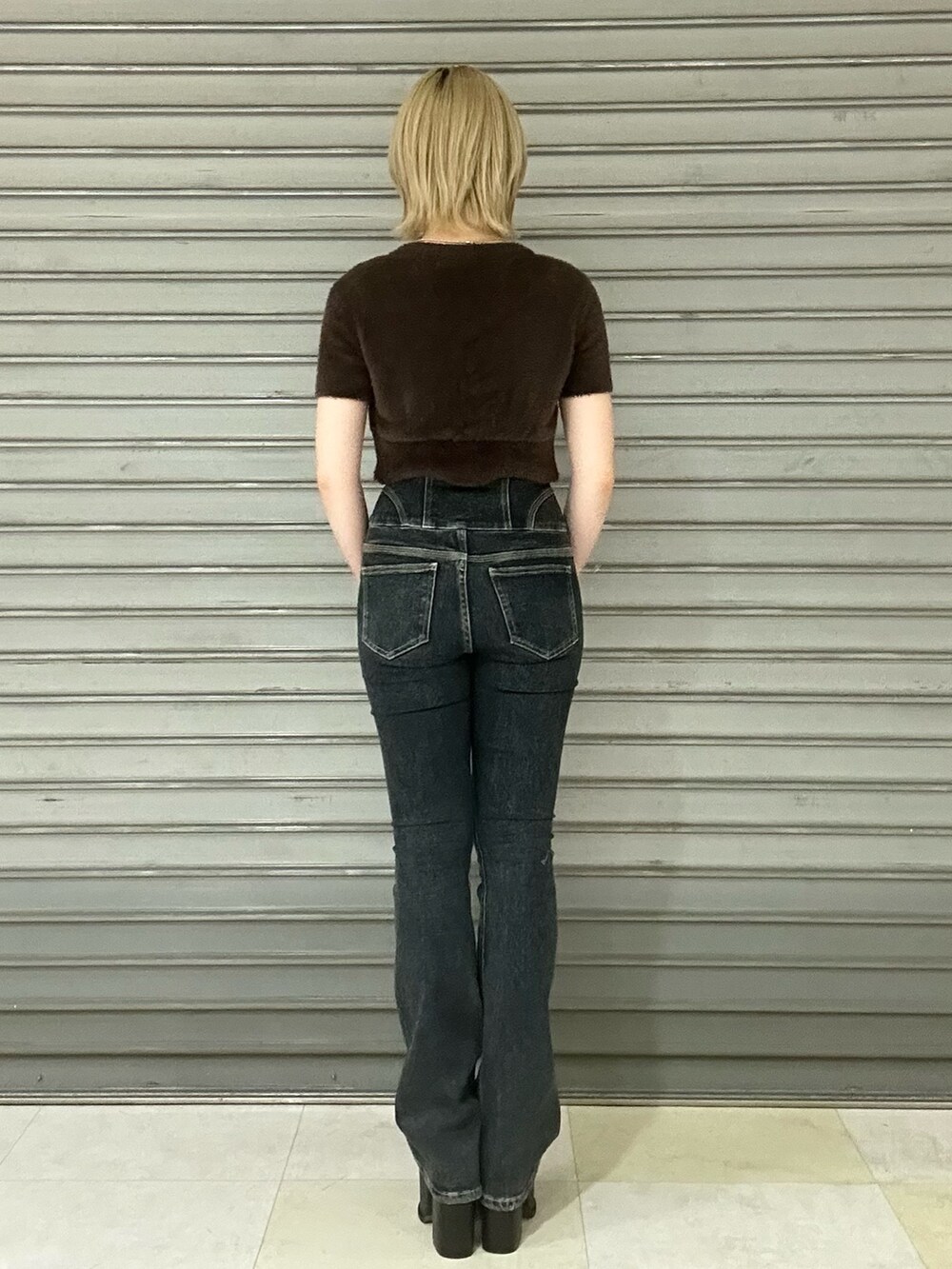 ブラック系のサンダル、ブルー系のデニムパンツ、ブラウン系のニット/セーターを着用したレディースの夏コーディネートの3枚目の写真