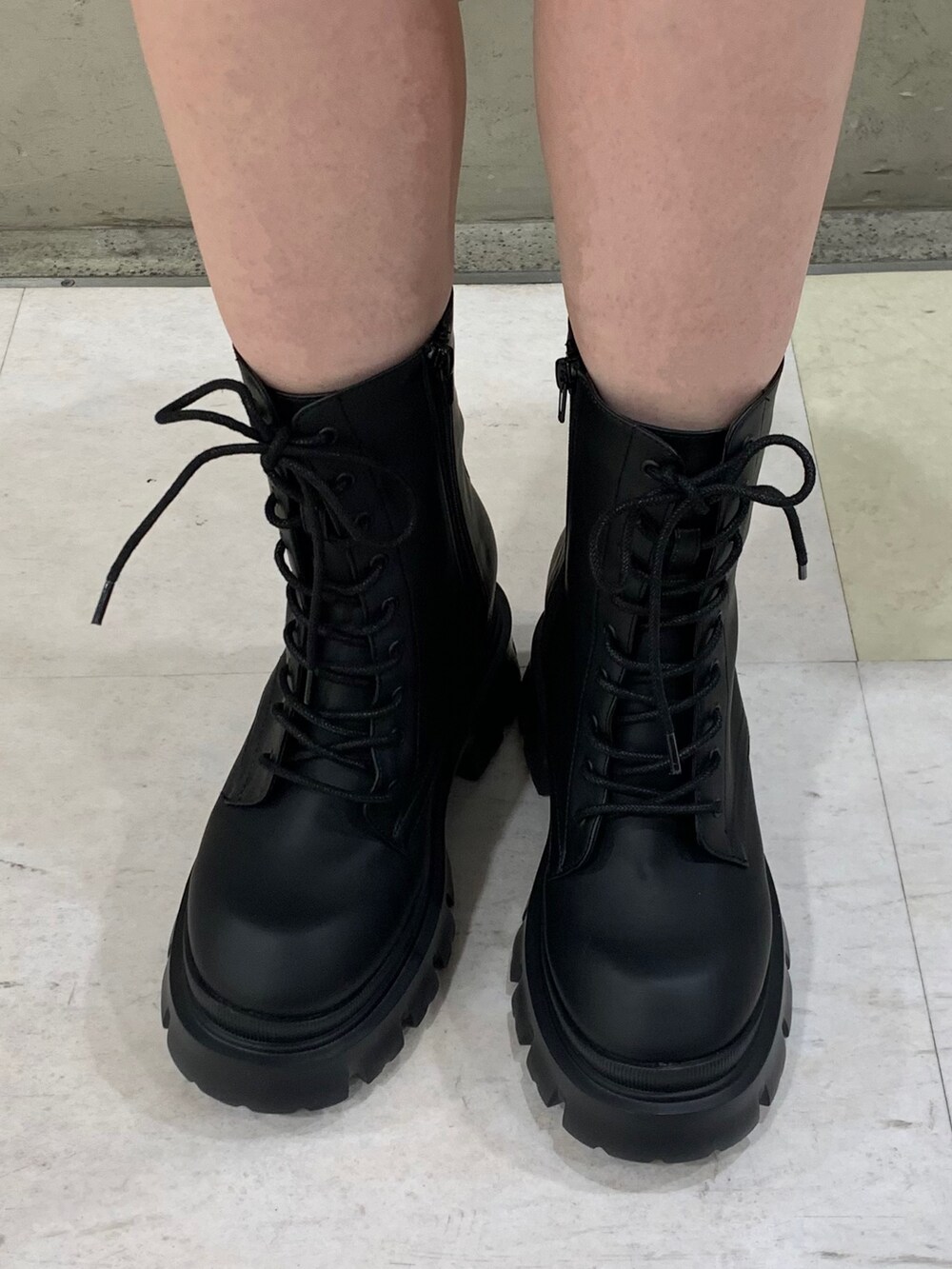 ホワイト系のキャミソール、ブラック系のブーツ、ブラック系のテーラードジャケットを着用したレディースの冬コーディネートの4枚目の写真