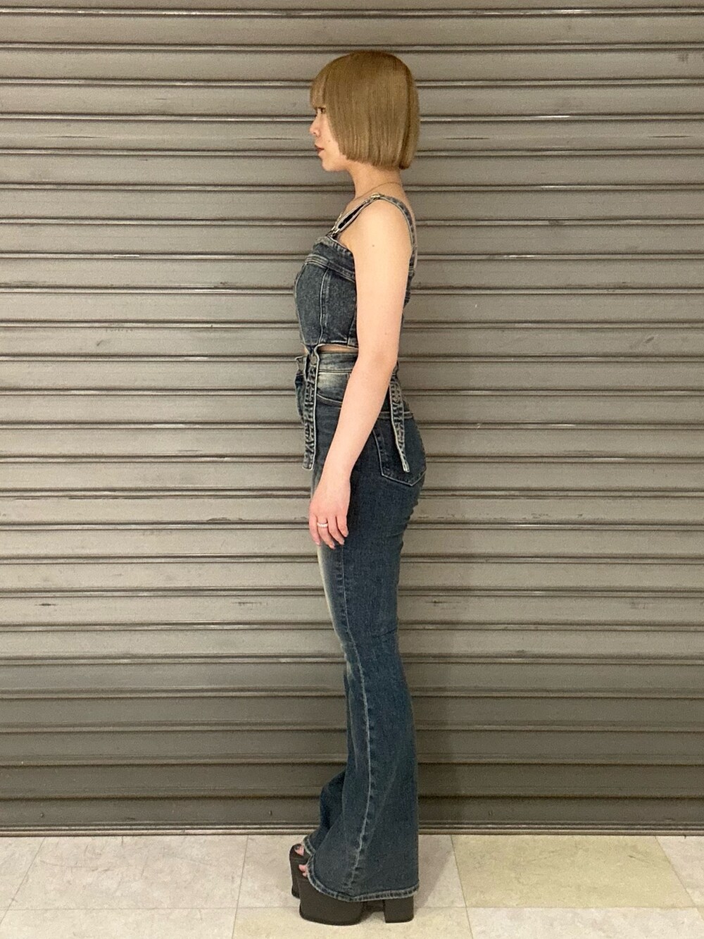 ブルー系のサロペット/オーバーオール、ホワイト系のシャツ/ブラウス、ブラック系のサンダルを着用したレディースの春コーディネートの5枚目の写真