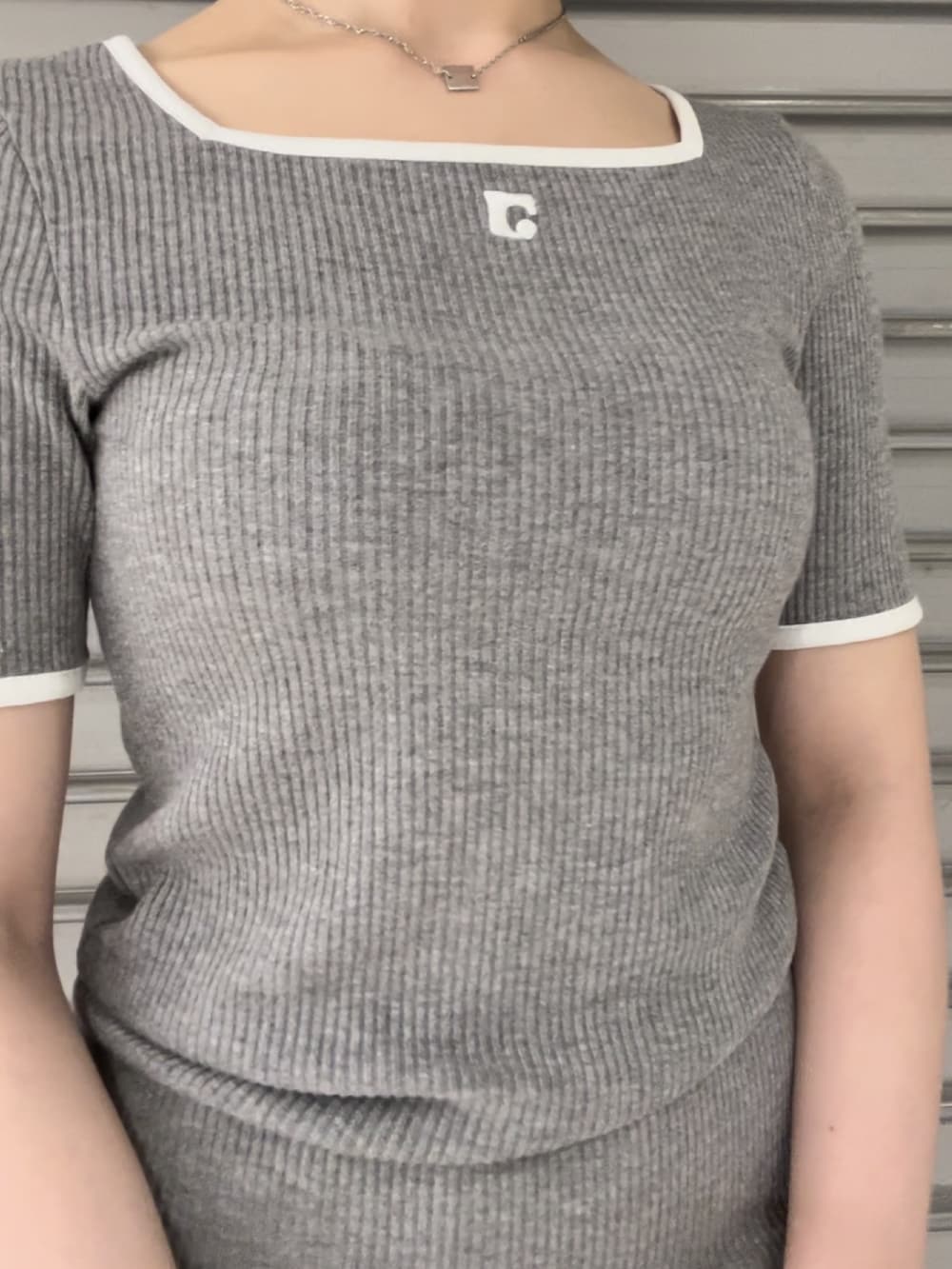 グレー系のワンピース、ブラック系のハンドバッグ、ブラック系のサンダルを着用したレディースの春コーディネートの4枚目の写真