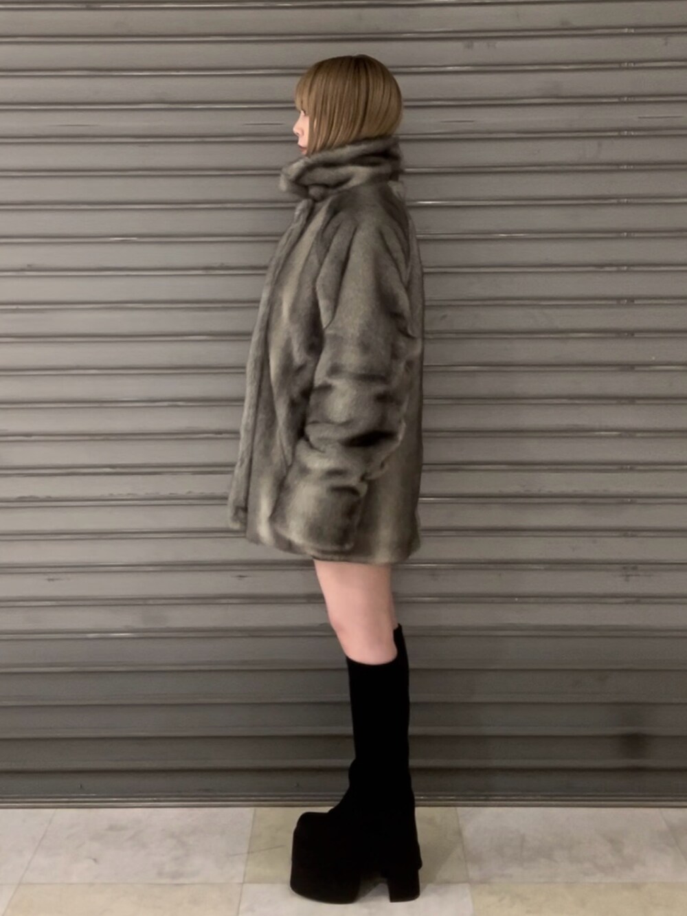 ブラック系のニット/セーター、グレー系のその他アウター、ブラック系のスカートを着用したレディースの冬コーディネートの4枚目の写真