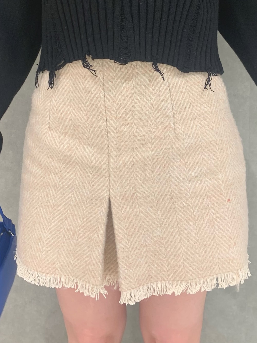 ブラック系のニット/セーター、ベージュ系のスカート、ブラック系のハンドバッグを着用したレディースの冬コーディネートの4枚目の写真