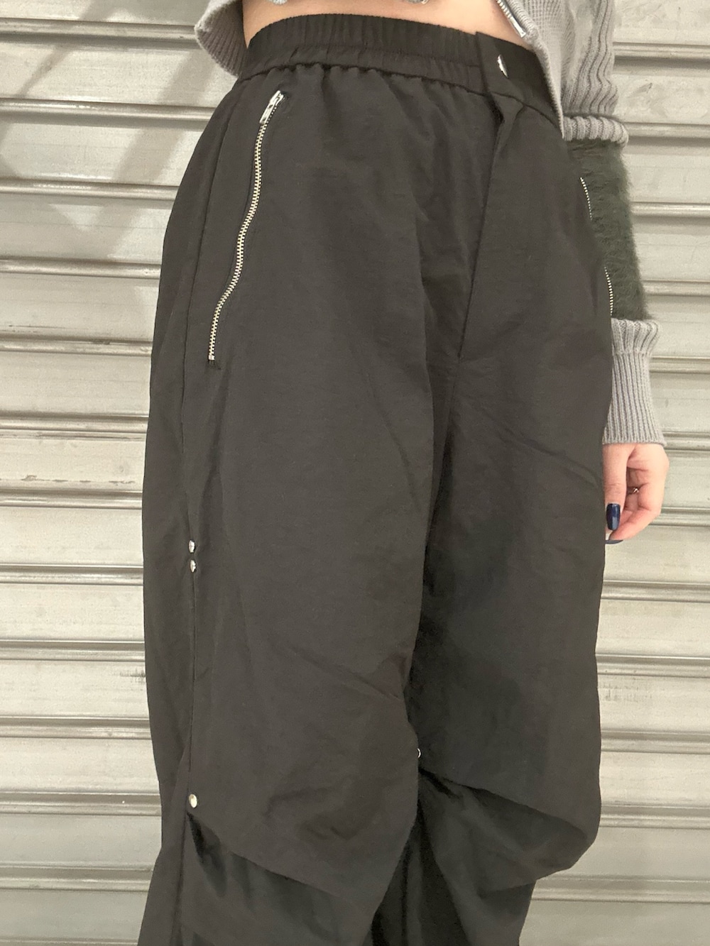 グレー系のニット/セーター、ブラック系のその他パンツ、シルバー系のボストンバッグを着用したレディースの冬コーディネートの5枚目の写真