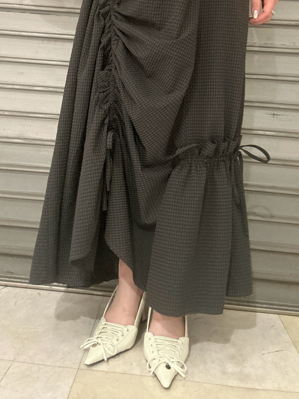 グレー系のワンピース、ホワイト系のハンドバッグ、ホワイト系のパンプスを着用したレディースの春コーディネートの6枚目の写真