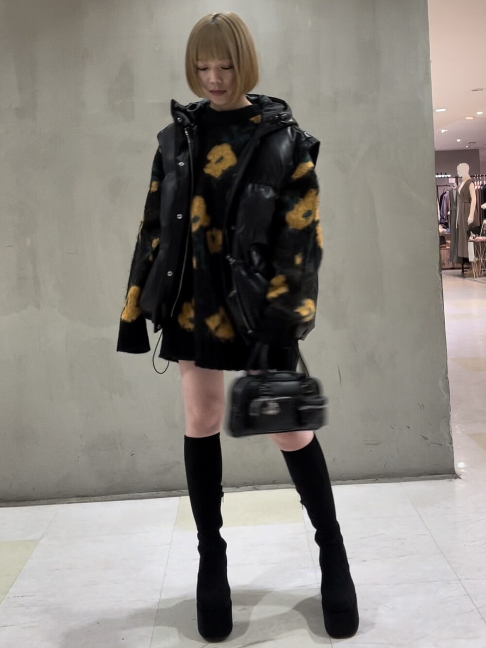 その他のブルゾン、オレンジ系のニット/セーター、ブラック系のハンドバッグを着用したレディースの秋コーディネートの4枚目の写真