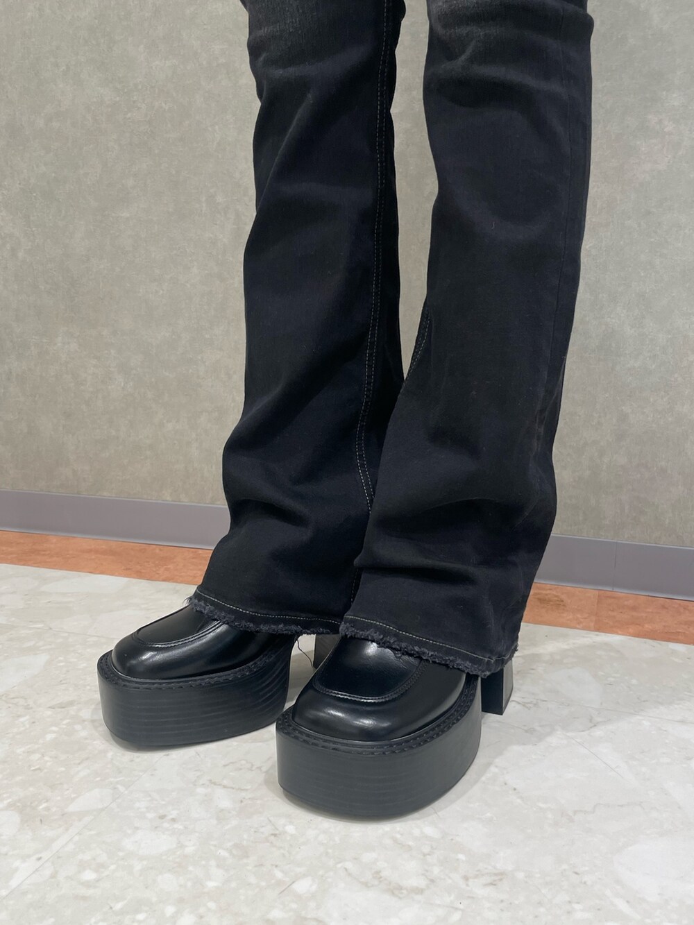 ブラック系のデニムパンツ、グレー系のニット/セーター、ブラック系のローファーを着用したレディースの冬コーディネートの5枚目の写真