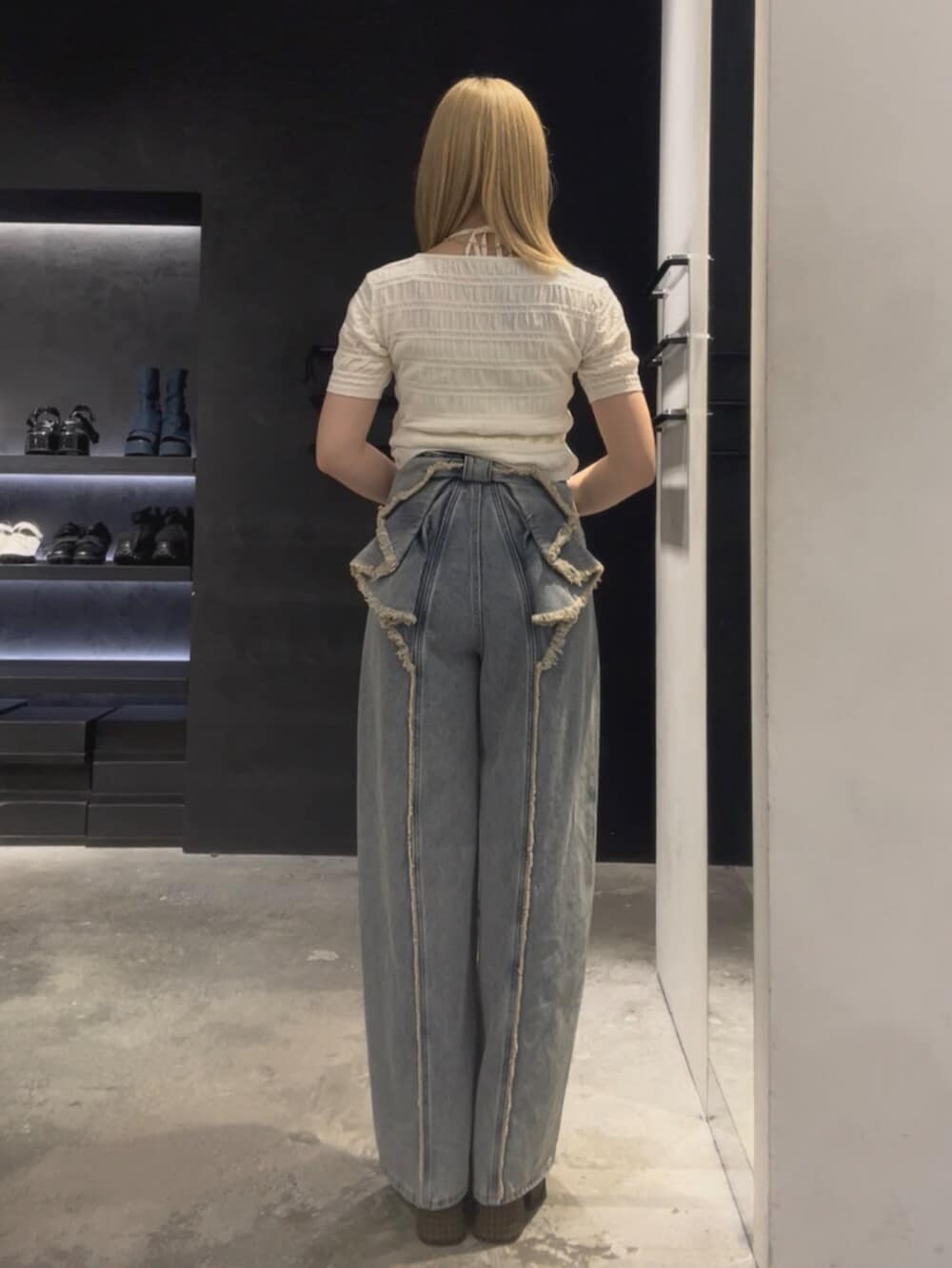 ホワイト系のニット/セーター、ブルー系のデニムパンツ、ベージュ系のサンダルを着用したレディースの夏コーディネートの3枚目の写真