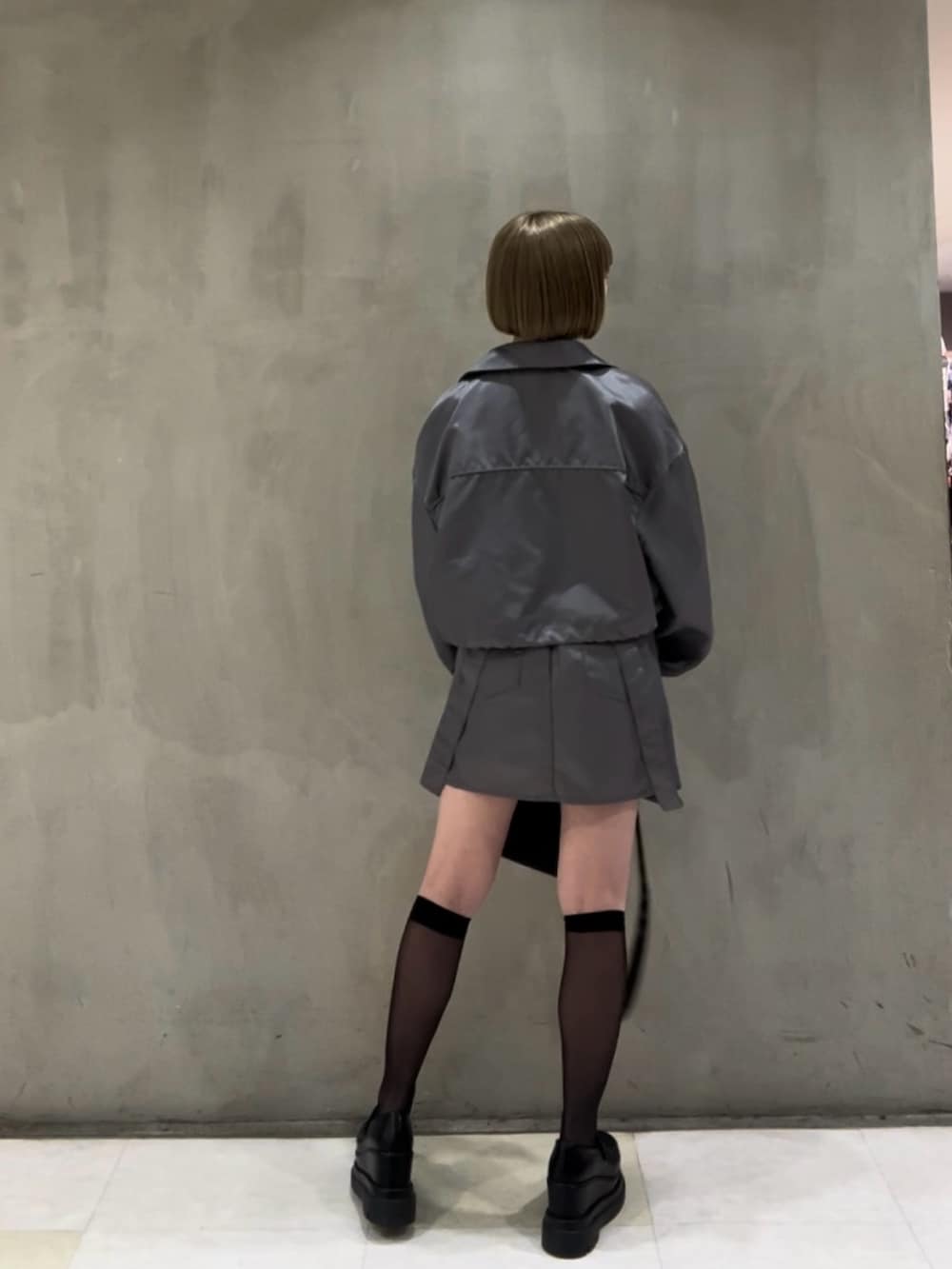 ホワイト系のキャミソール、ブラック系のショルダーバッグ、グレー系のブルゾンを着用したレディースの冬コーディネートの3枚目の写真