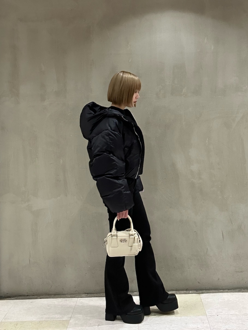 ホワイト系のダウンジャケット/コート、ブラック系のニット/セーター、ブラック系のデニムパンツを着用したレディースの冬コーディネートの3枚目の写真