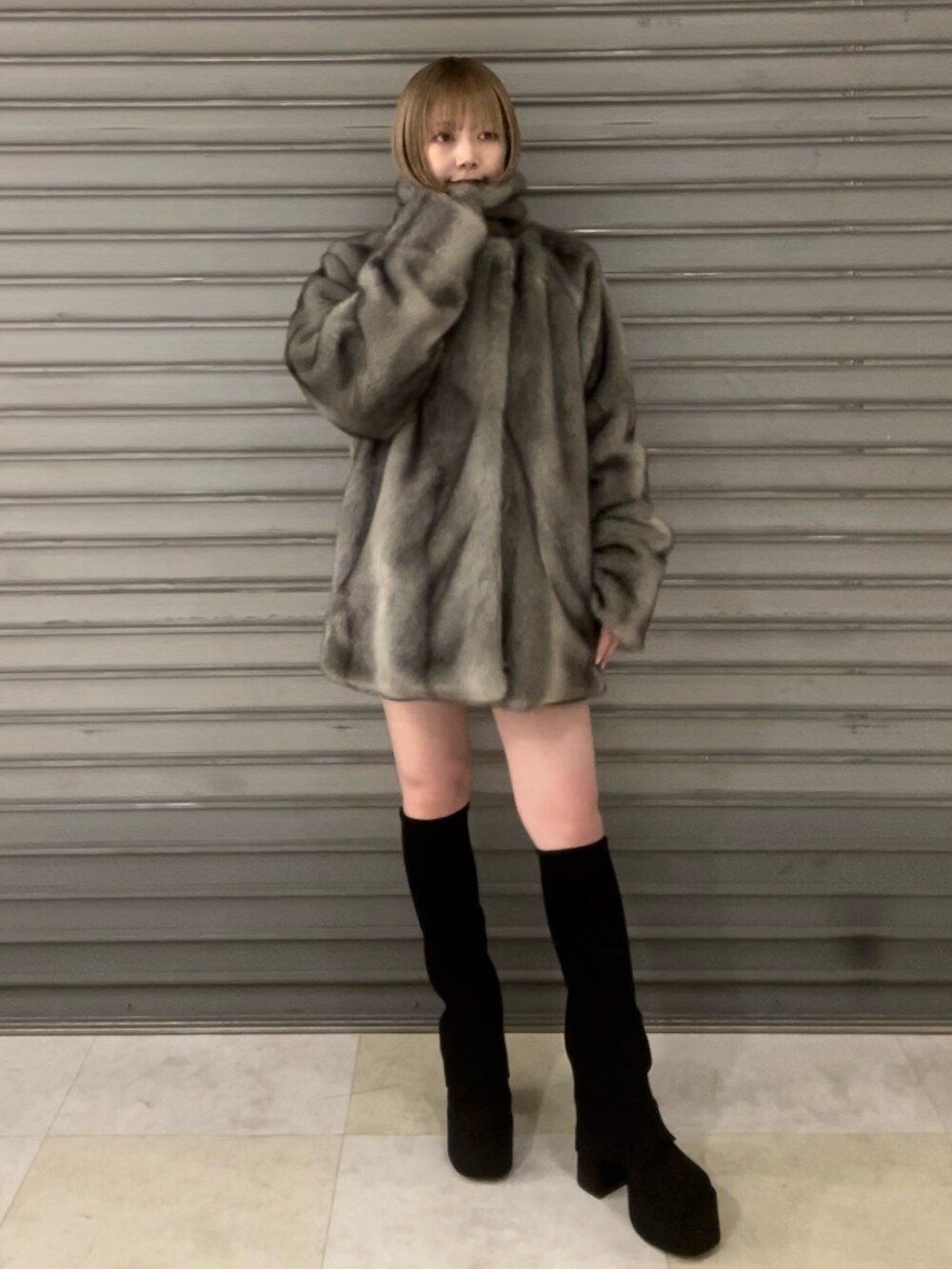 ブラック系のニット/セーター、グレー系のその他アウター、ブラック系のスカートを着用したレディースの冬コーディネートの2枚目の写真