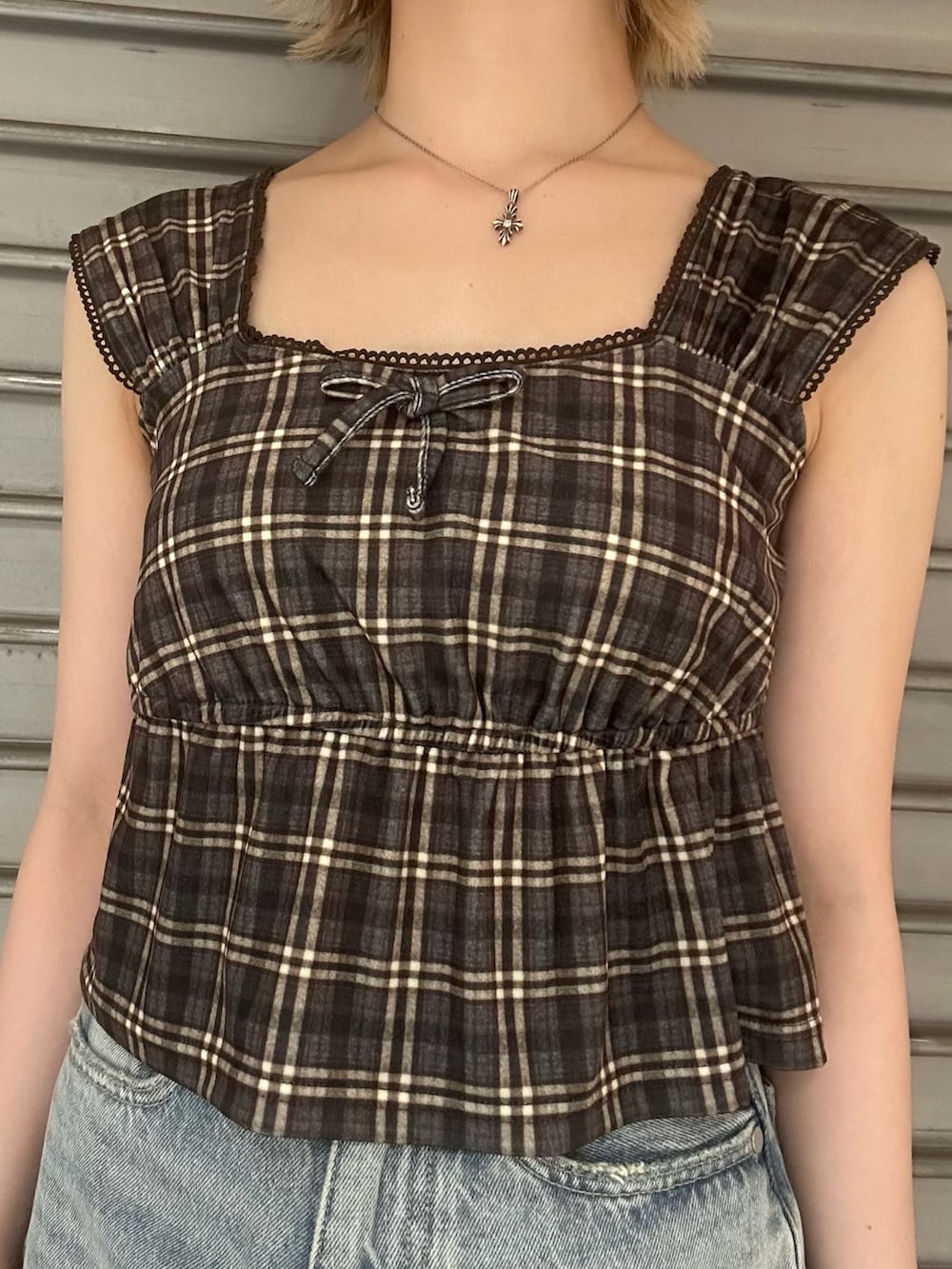 ブラウン系のタンクトップ、ブルー系のデニムパンツ、ブラック系のサンダルを着用したレディースの夏コーディネートの4枚目の写真