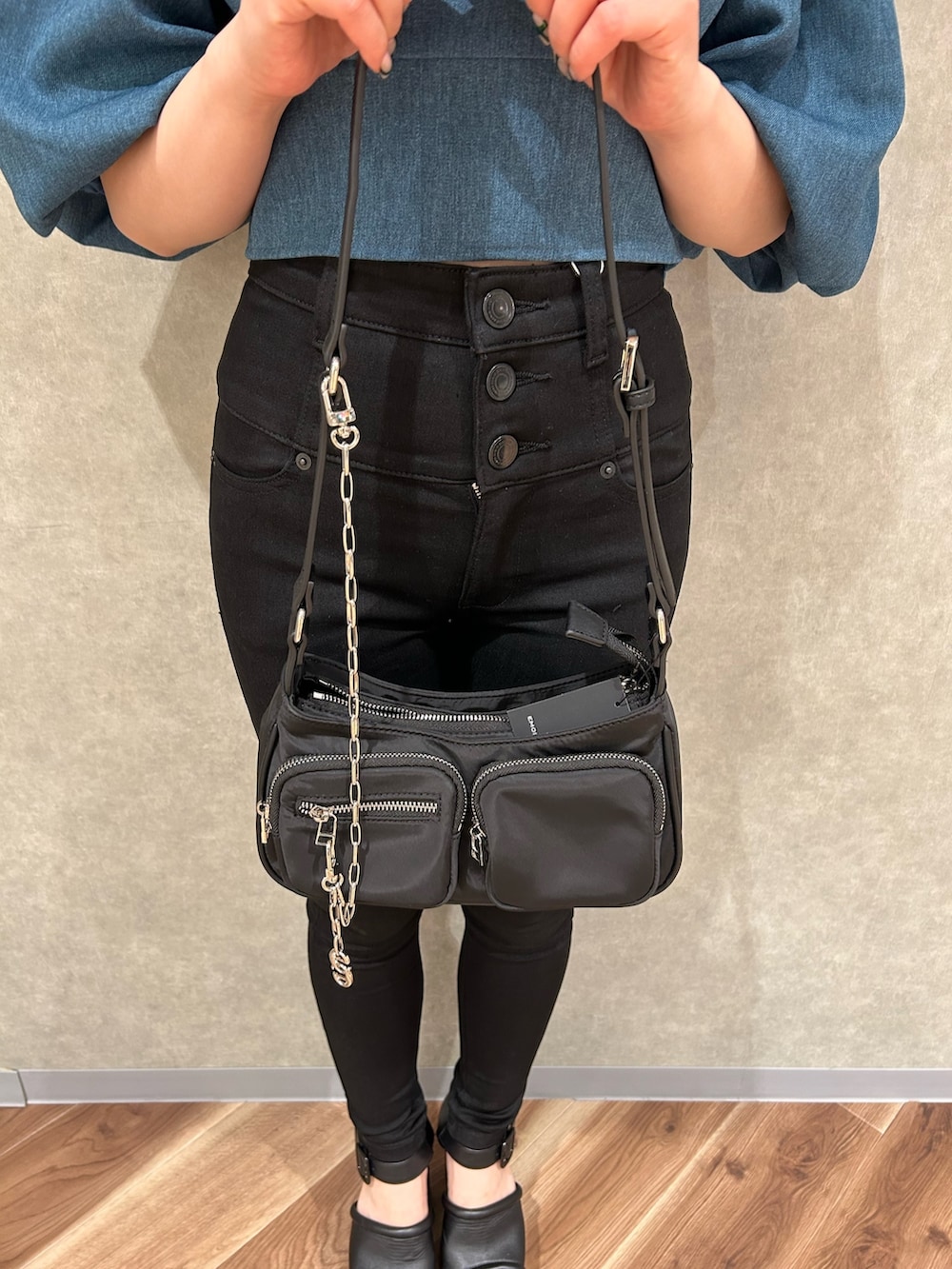 ブラック系のデニムパンツ、ブルー系のTシャツ/カットソー、ブラック系のハンドバッグを着用したレディースの夏コーディネートの6枚目の写真