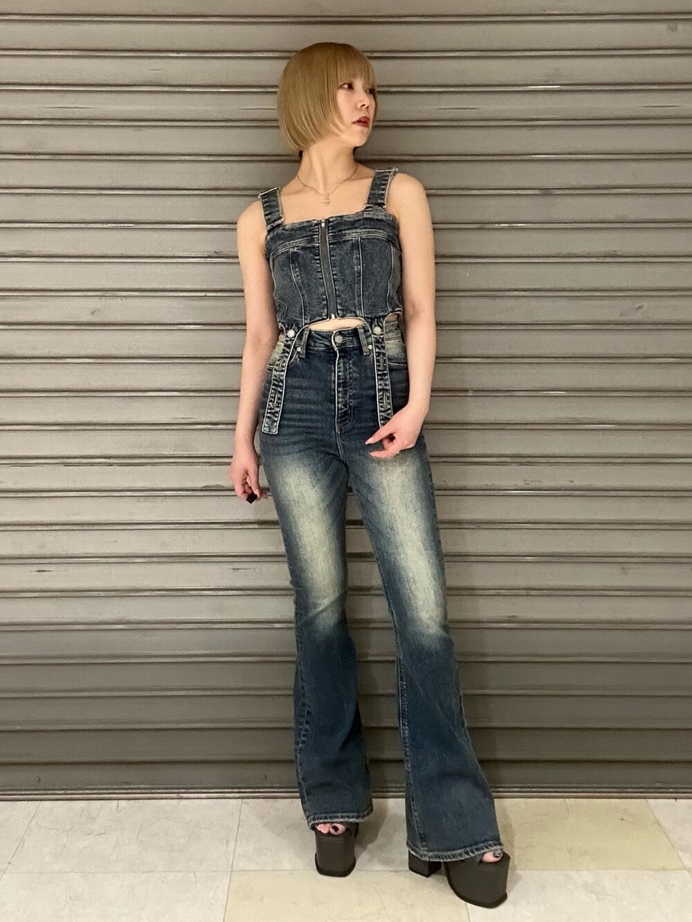 ブルー系のサロペット/オーバーオール、ホワイト系のシャツ/ブラウス、ブラック系のサンダルを着用したレディースの春コーディネートの4枚目の写真