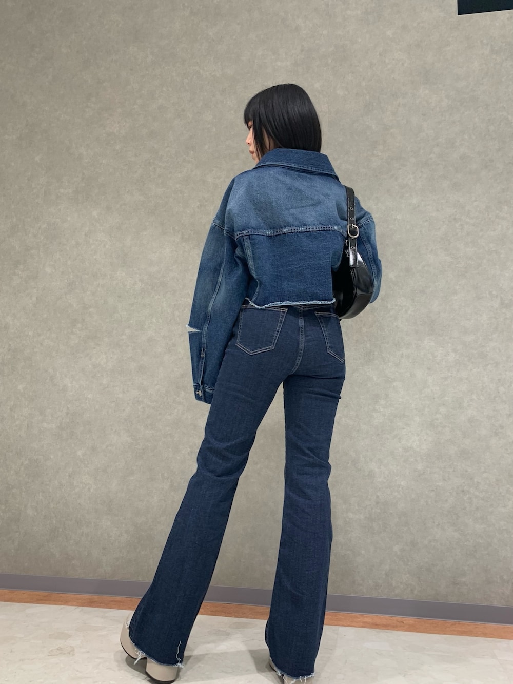 ブルー系のデニムパンツ、ブルー系のデニムジャケット、ブラック系のキャミソールを着用したレディースの春コーディネートの2枚目の写真