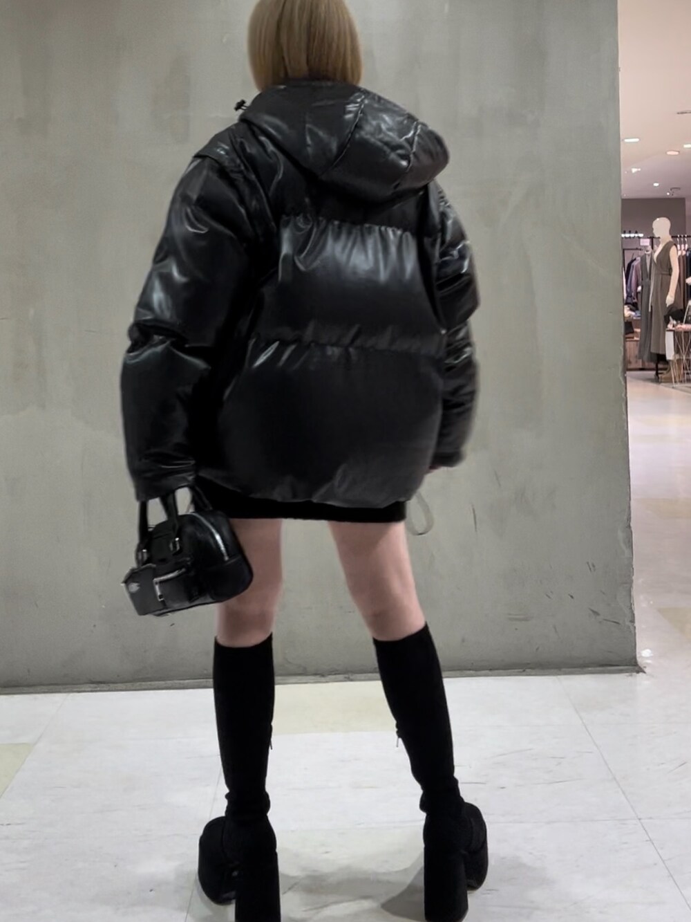 その他のブルゾン、オレンジ系のニット/セーター、ブラック系のハンドバッグを着用したレディースの秋コーディネートの3枚目の写真