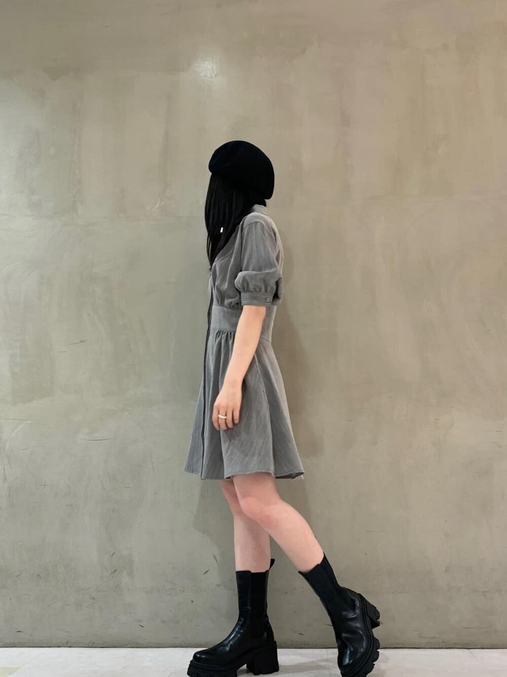 グレー系のワンピース、ブラック系のブーツ、ブラック系のハンチング/ベレー帽を着用したレディースの夏コーディネートの2枚目の写真