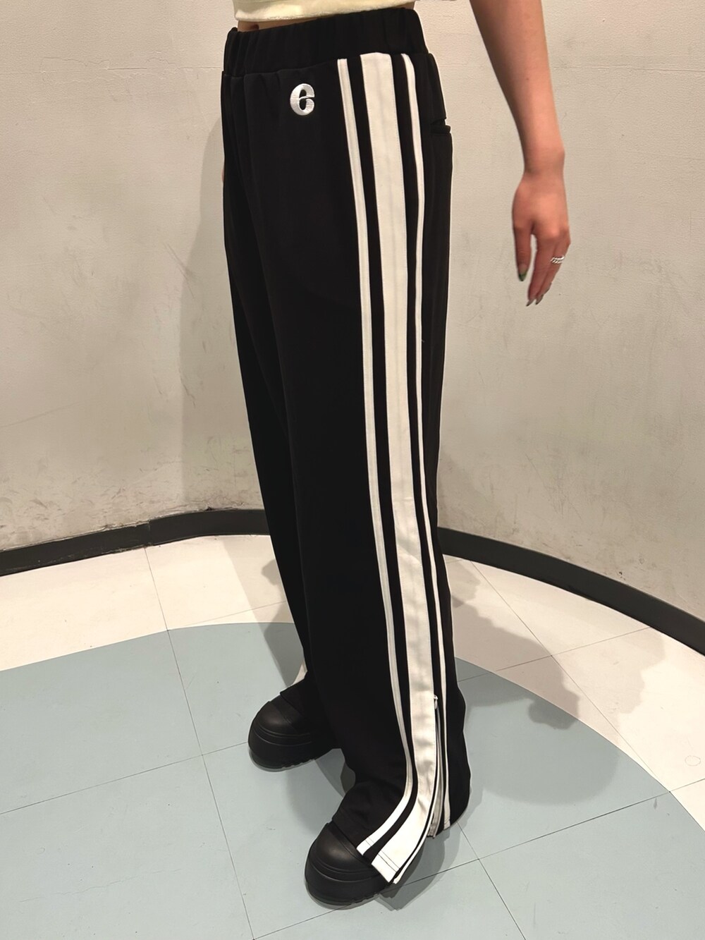 ホワイト系のTシャツ/カットソー、ブラック系のその他パンツ、ブラック系のブーツを着用したレディースの夏コーディネートの4枚目の写真