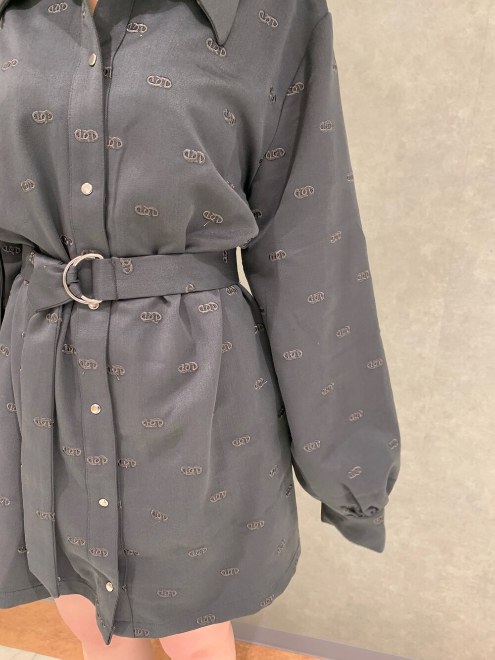 グレー系のワンピース、ブラック系のハンドバッグ、ブラック系のブーツを着用したレディースの冬コーディネートの3枚目の写真